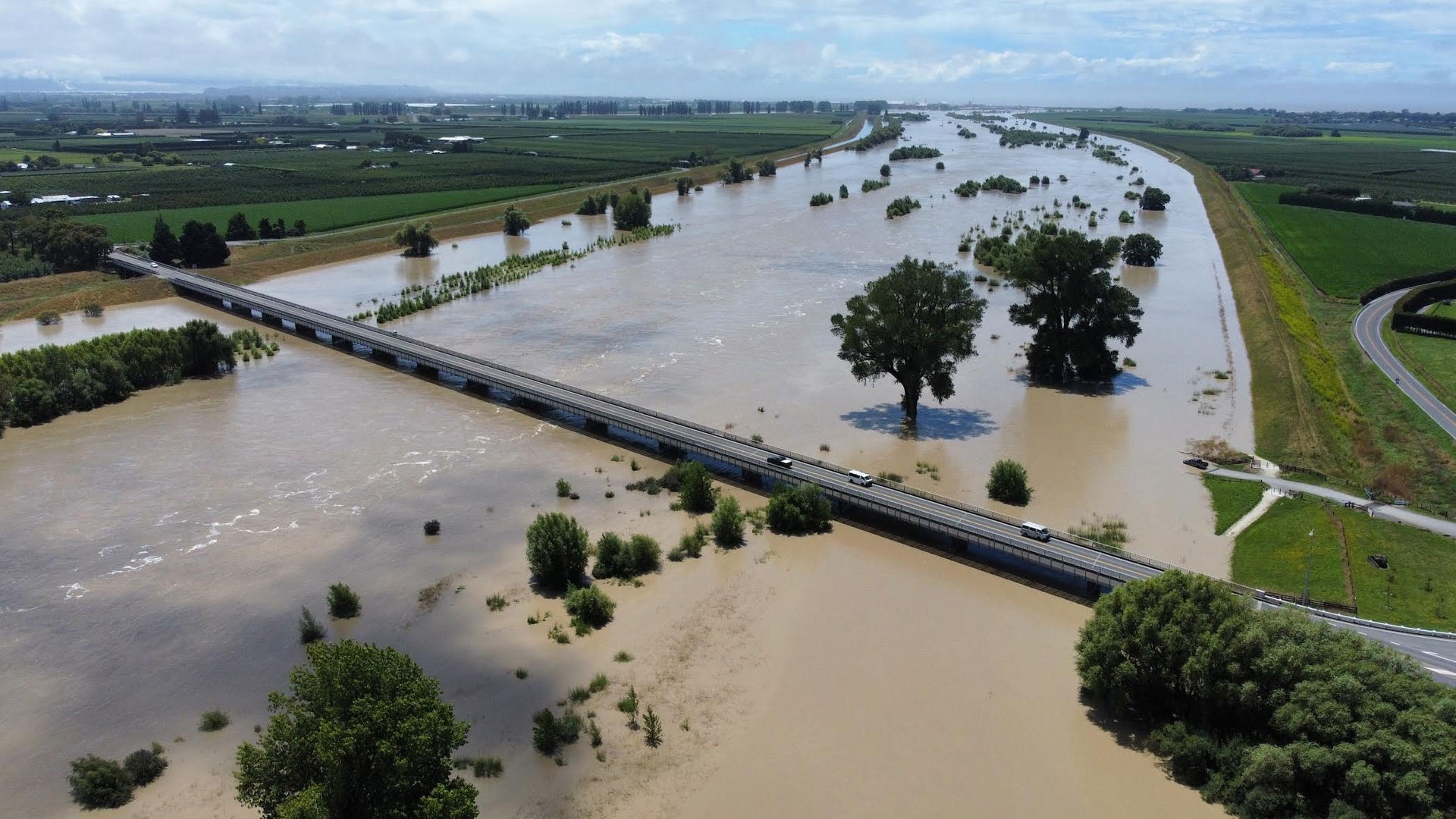 A flooded river that it has burst its banks in NZ.