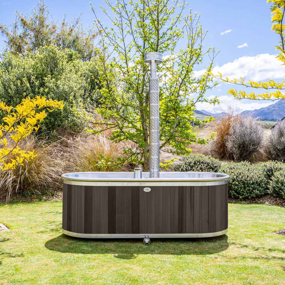 This wood-fired outdoor bath by Stoked Stainless offers the perfect antidote to a busy life, and a decadent place to bathe surrounded by nature. Here, privacy and protection is created with trees and landscaping. 