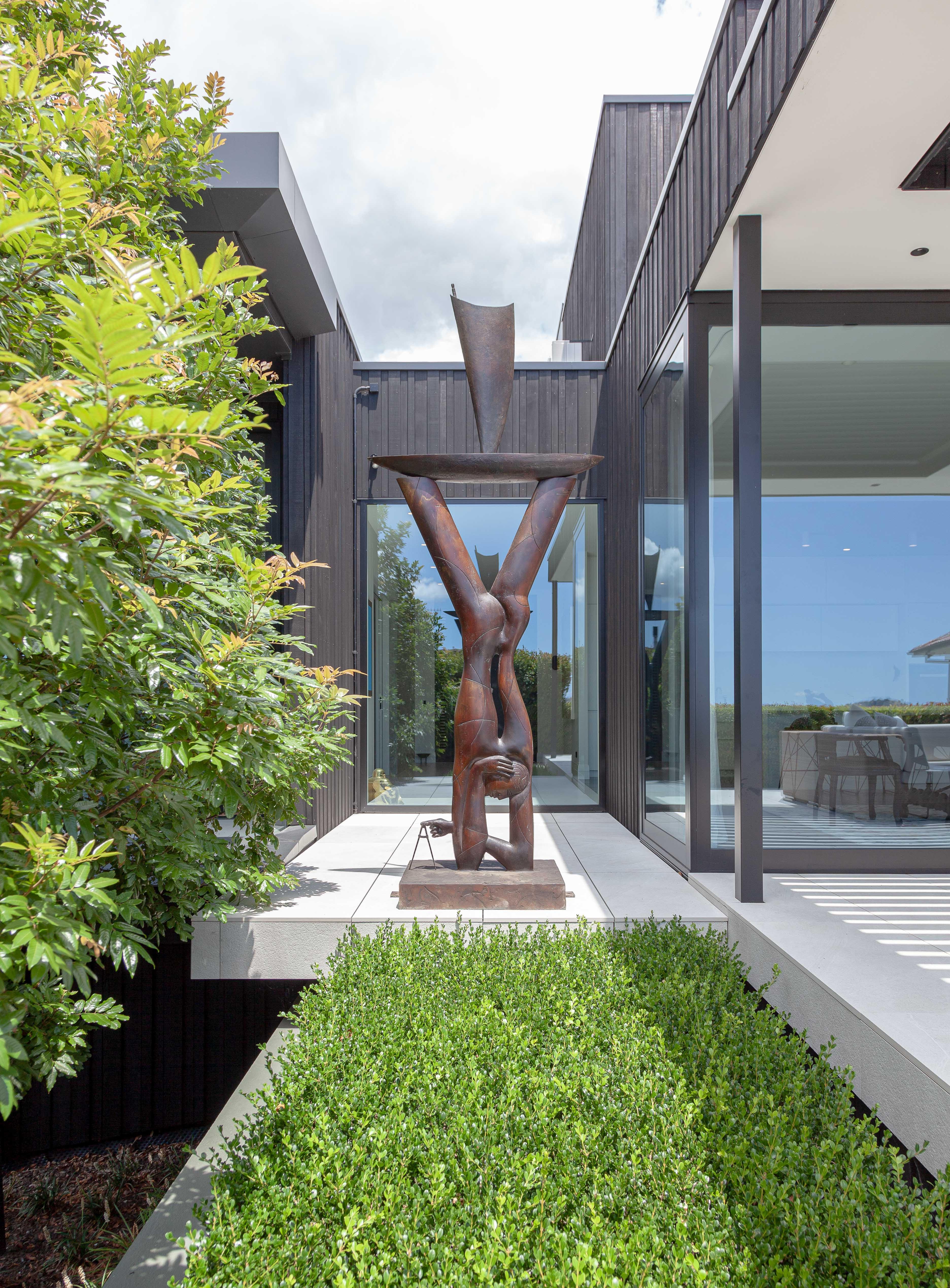 Here, a Paul Dibble sculpture is used as the focal point. This home designed by Jessop Architects unfolds around a simple, low maintenance garden designed by Jared Lockhart. Image - John Williams. 