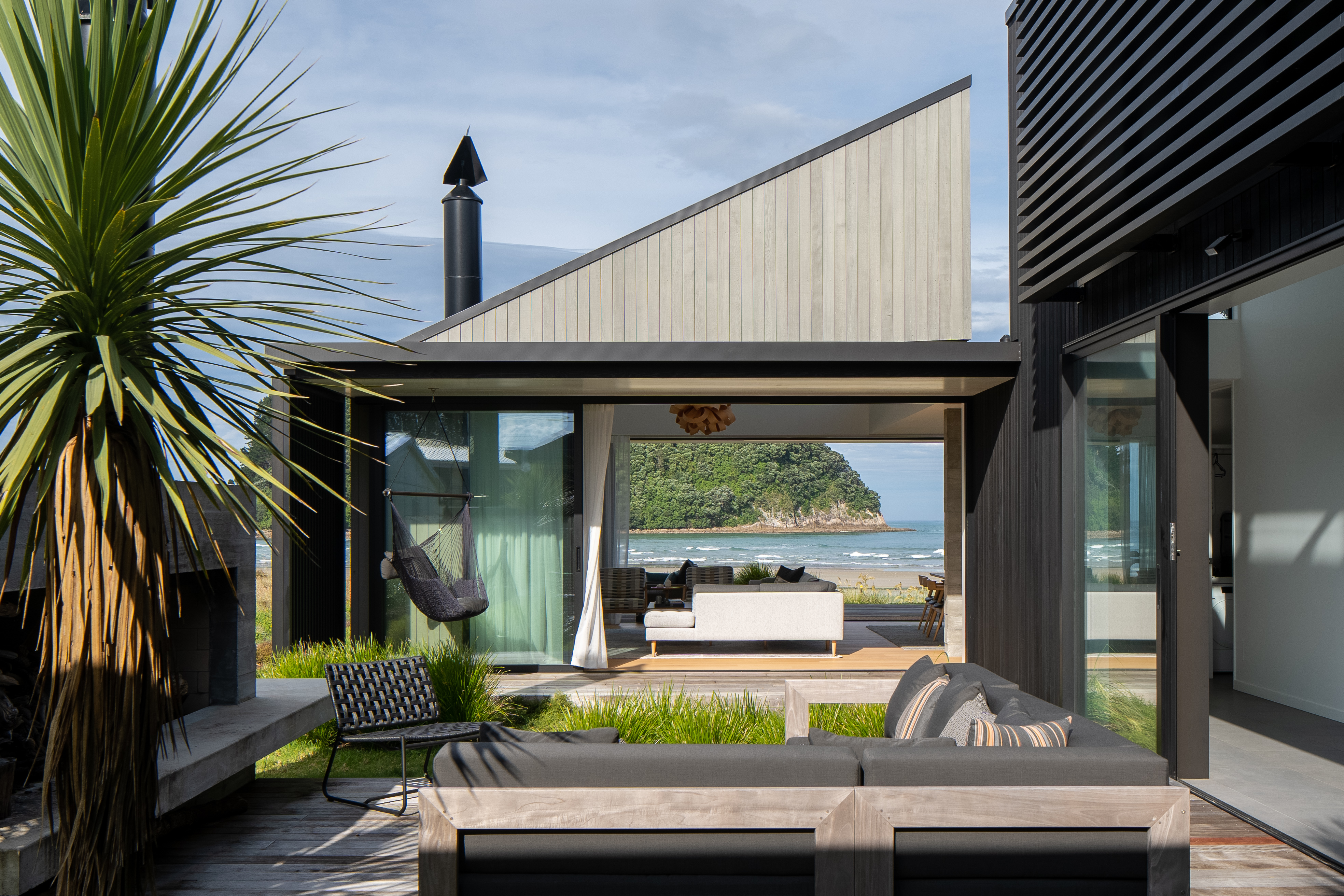 A U-shaped bach on a beachfront site in Whangamatā with a north-facing courtyard at its centre