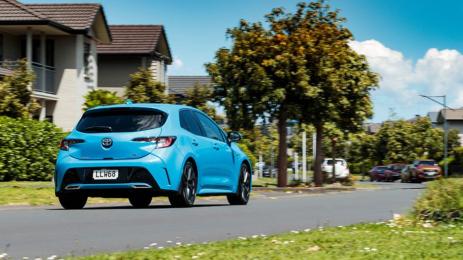 Blue Toyota Corolla Hybrid ZR driving rear shot.