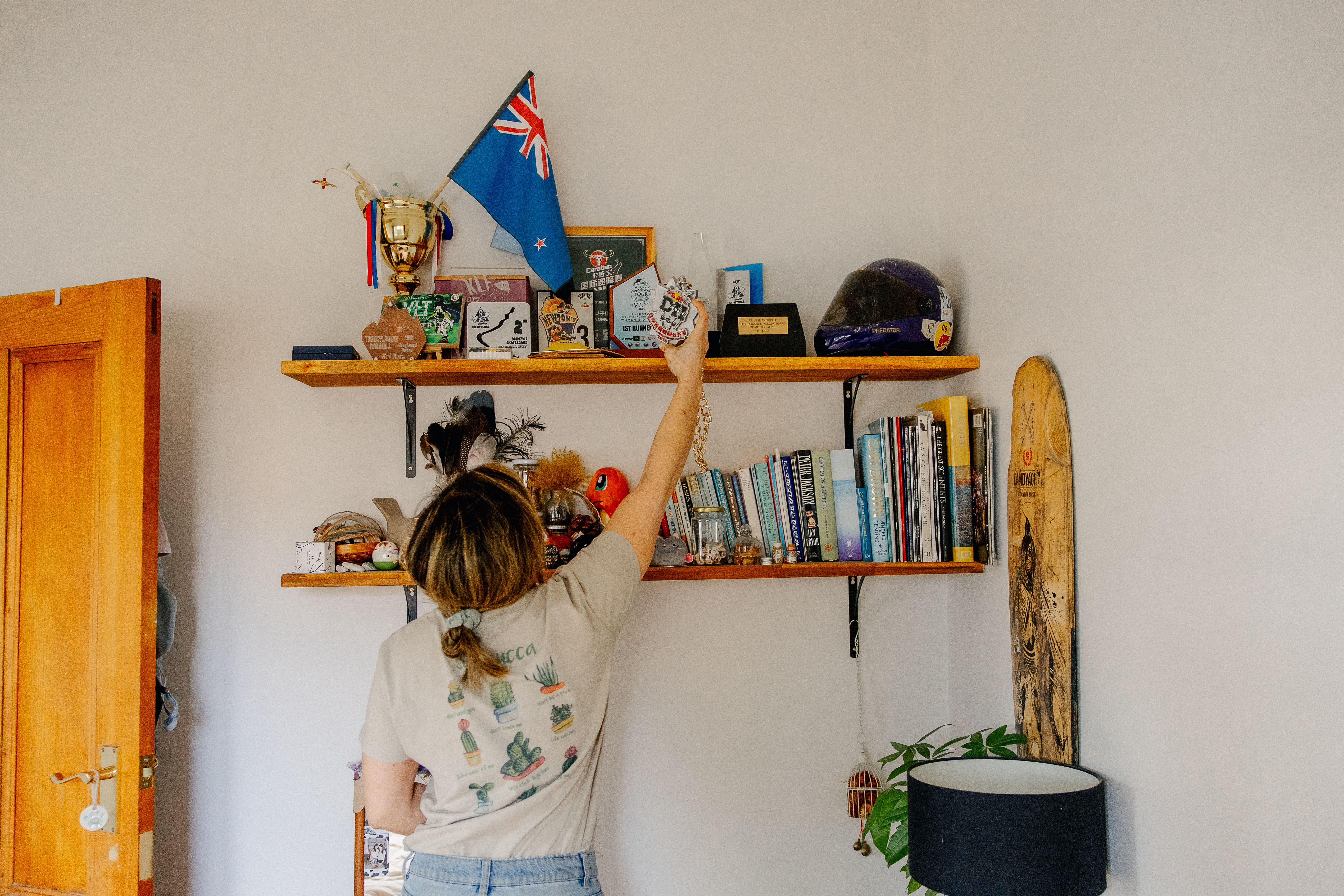 Elissa reaches up to her bookcase