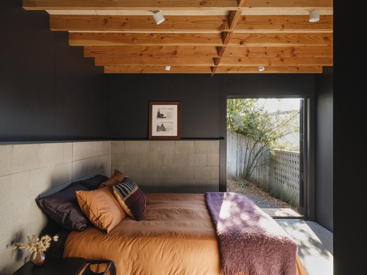 Second bedroom with visual warmth and a door leading outside.