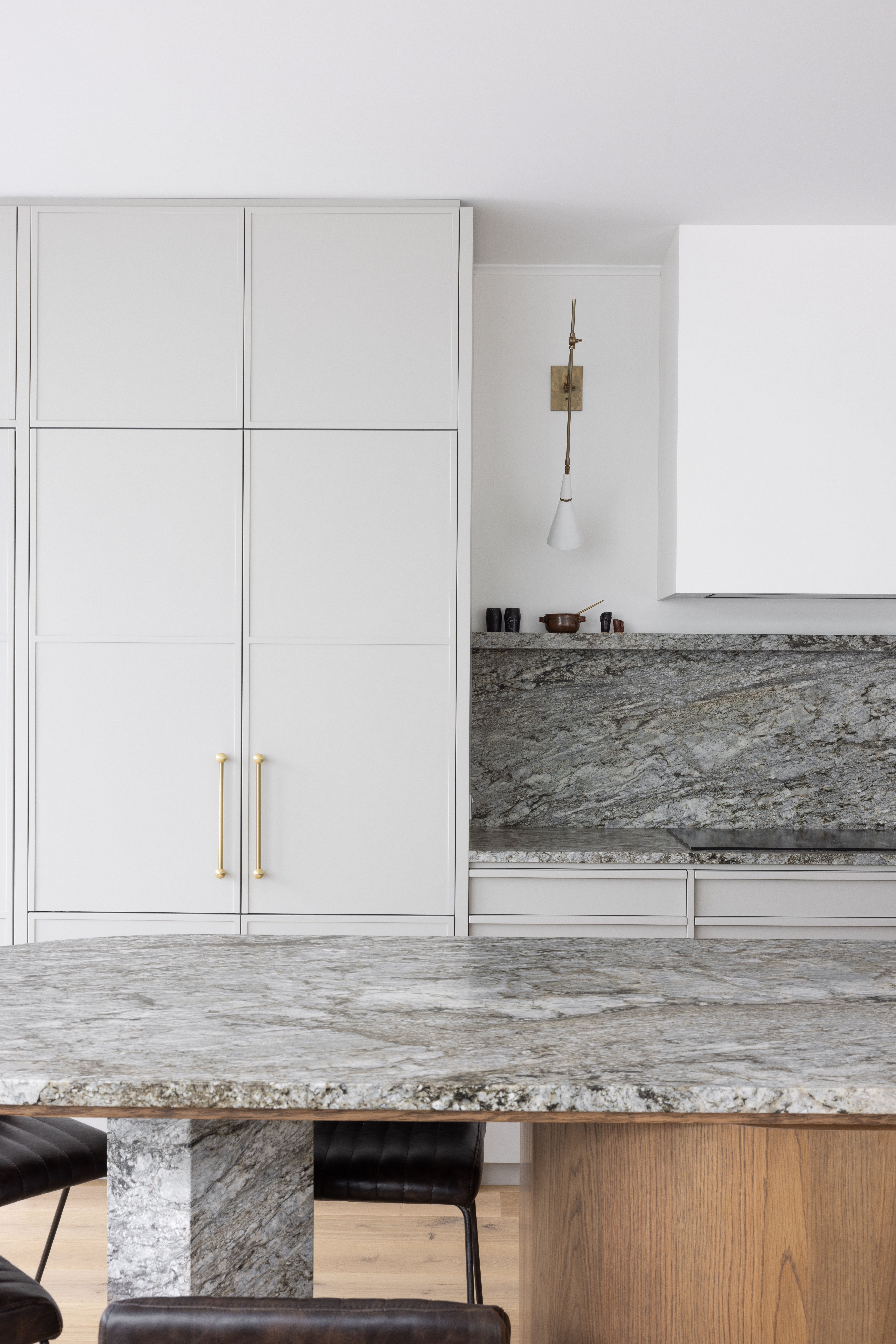Isabelle engaged Finesse Joinery on the fitout of the kitchen, opting for soft grey cupboards with Lo & Co’s Sphere Pull polished brass handles. The benchtop is from The Granite Benchtop Company and is made from two unique book-matched pieces, aligned so the grain matches up. The installers even painted the grout between the pieces to match the grain, making it appear as one enormous stone slab.