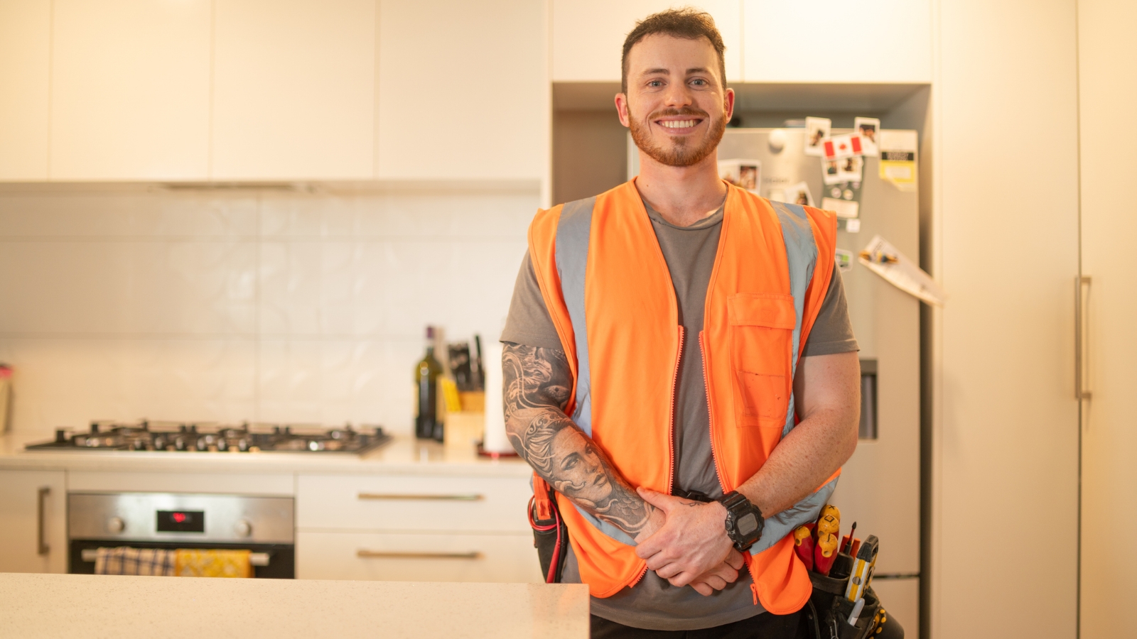 Builder's apprentice in kitchen with high vis on. 