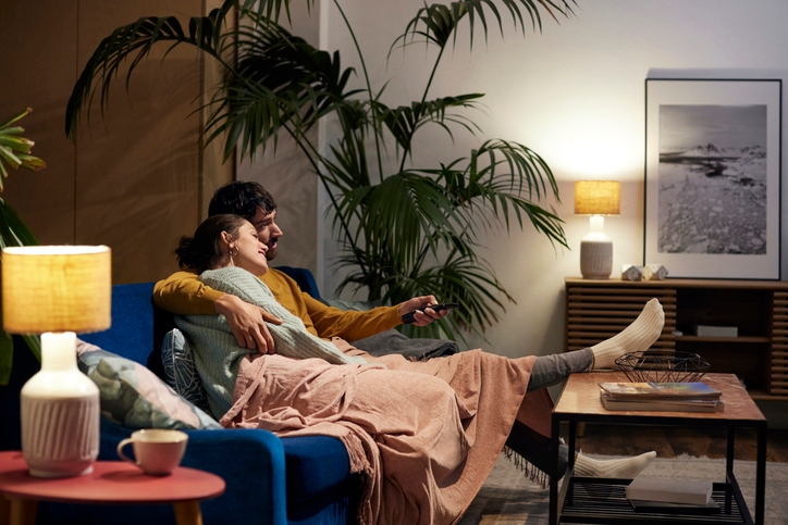 A couple sitting on a cozy sofa, sharing a warm and comfortable moment together.