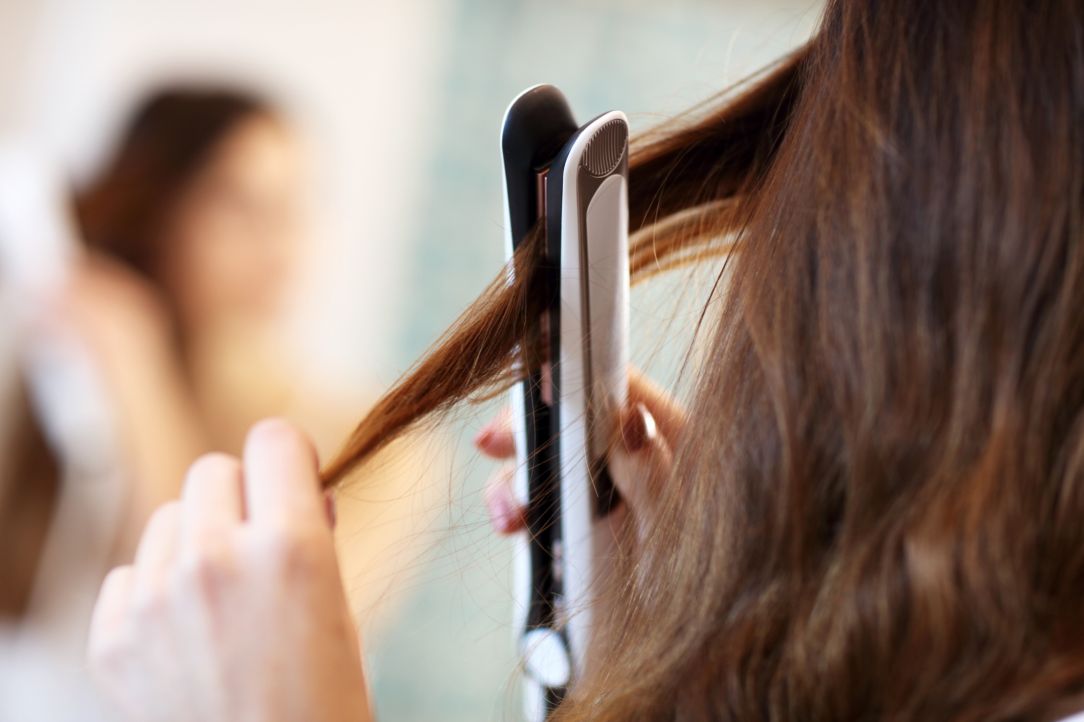 A woman using a hair straightener