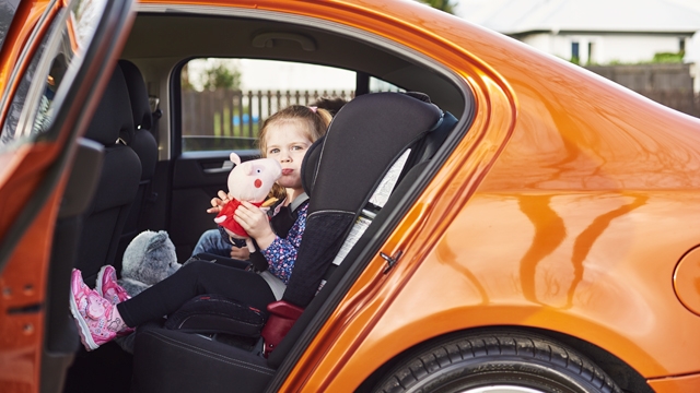 Child in car seat with cuddly toy