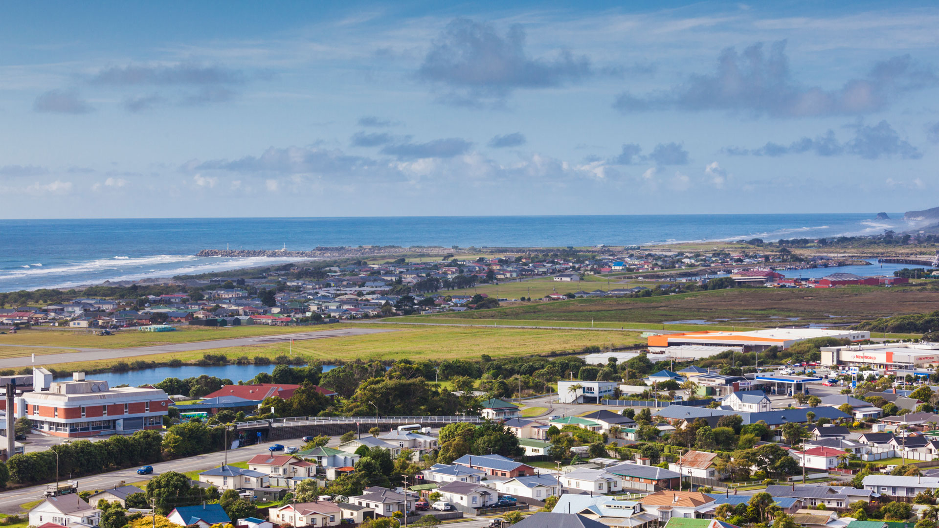 A view of houses in Greymouth, with the ocean in the background.