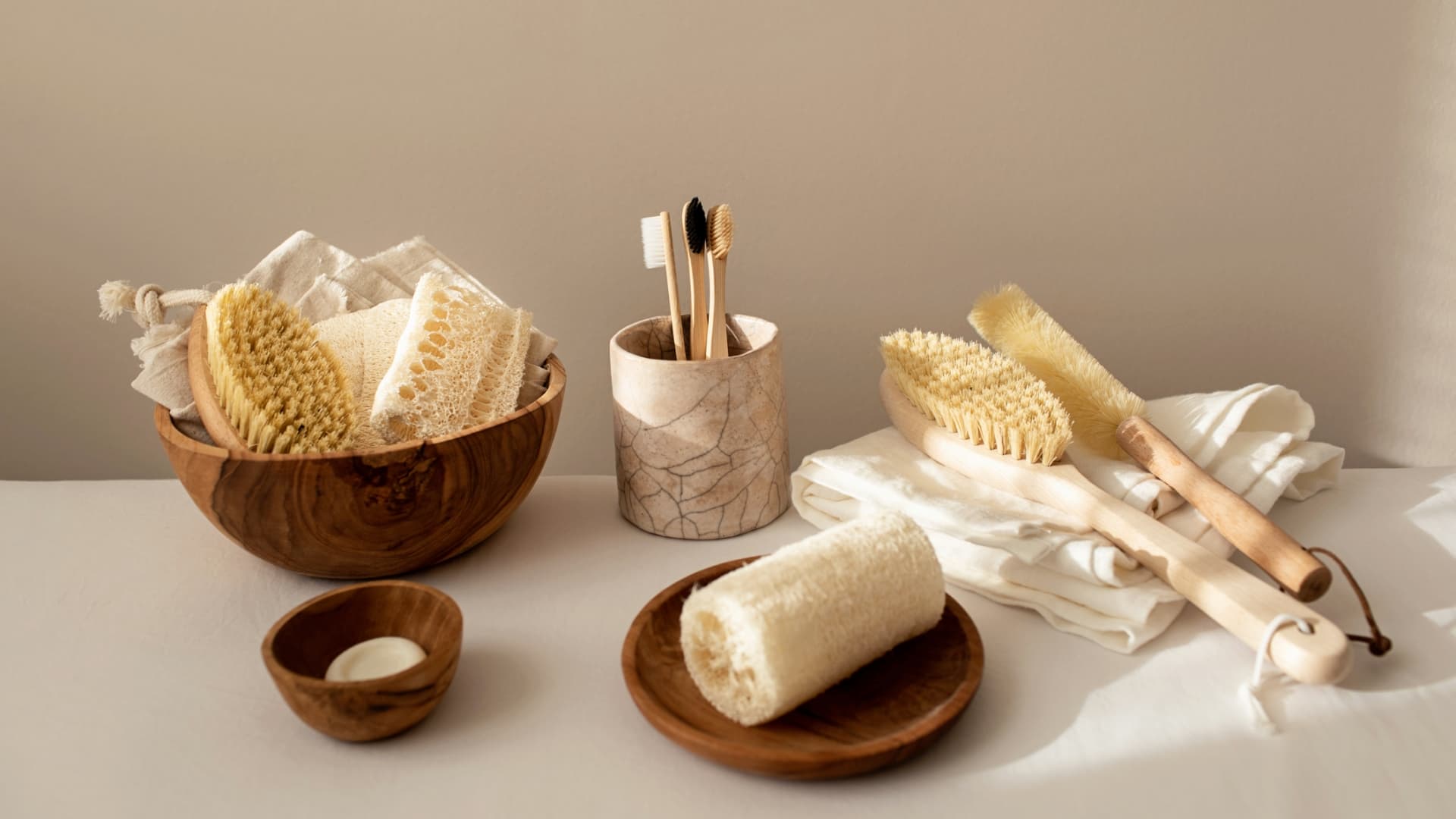 Styled flat lay of environmentally friendly bathroom products including clothes, brushes and toothbrushes.