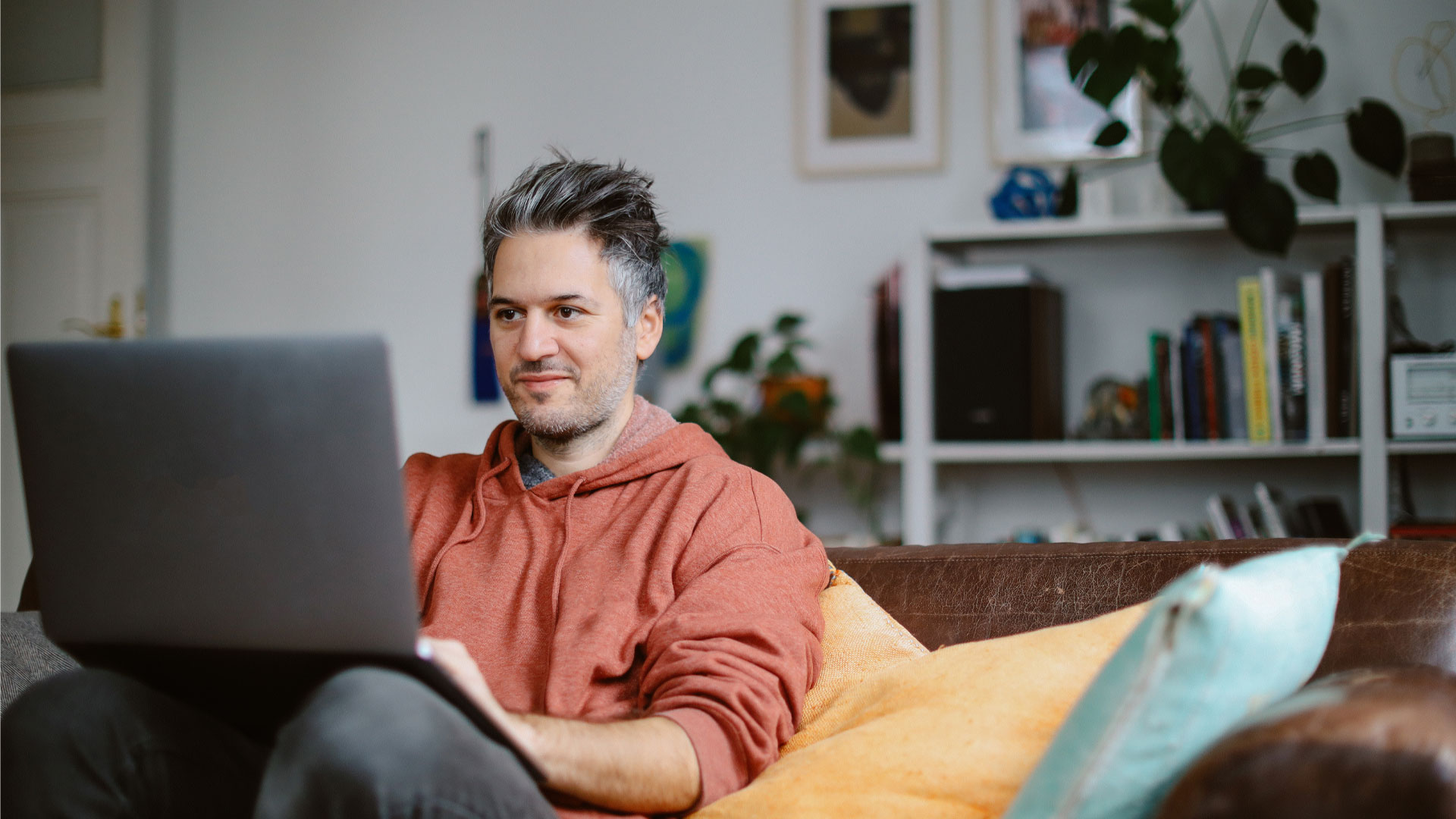 Man sitting with his laptop at home looking for jobs in NZ.
