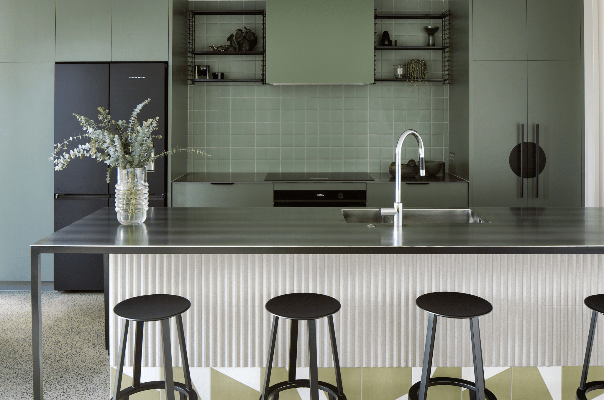 Slate green forms the backdrop of this modern English-style kitchen, which also incorporates accents of black and white. Image: Simon Wilson