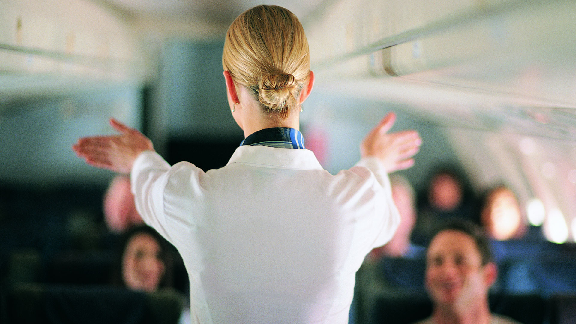 Cabin crew staff member giving safety instructions before take off.