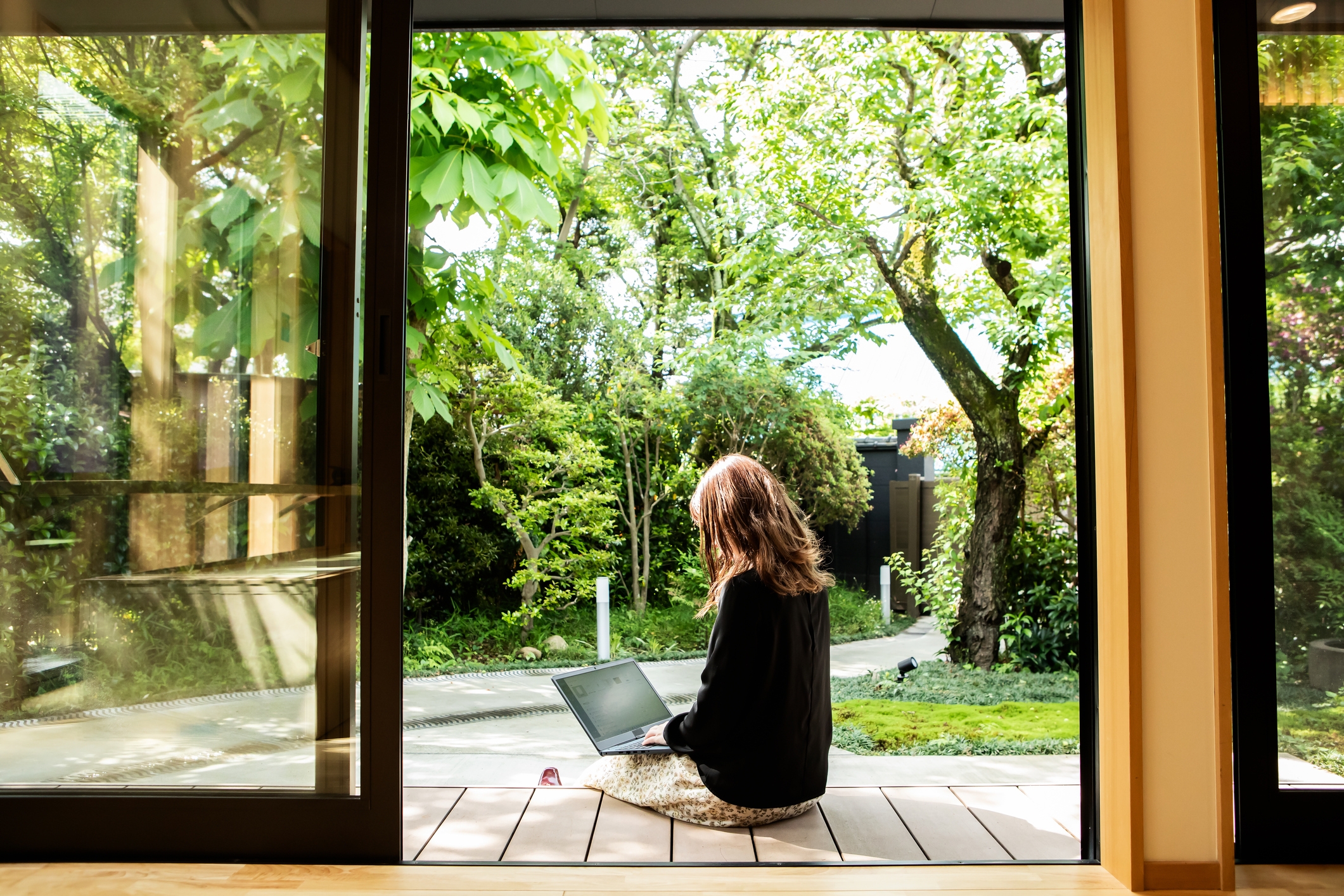 Do you need life insurance for a mortgage? Lady sitting on laptop on deck. 