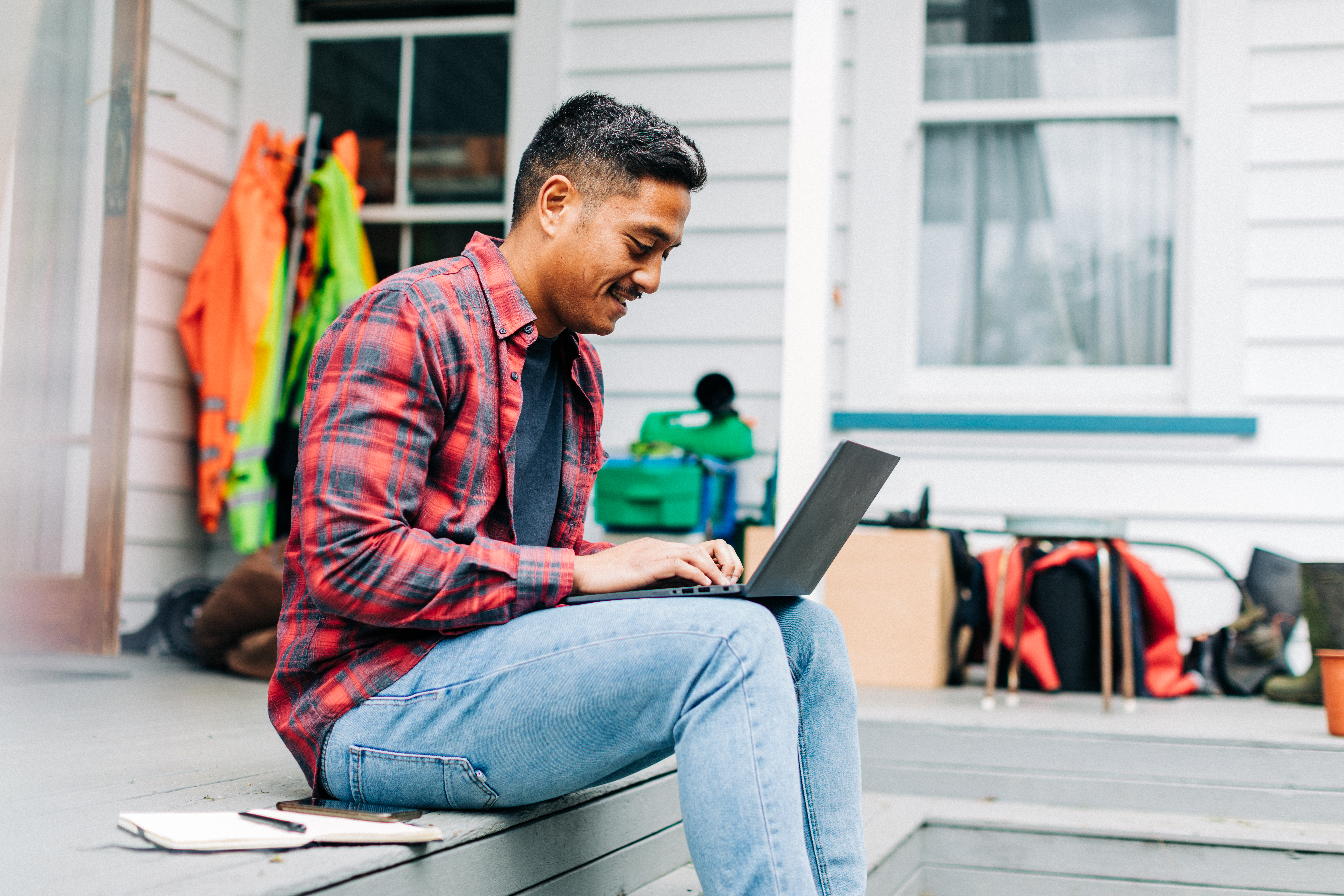 Man sitting down on his deck with his laptop