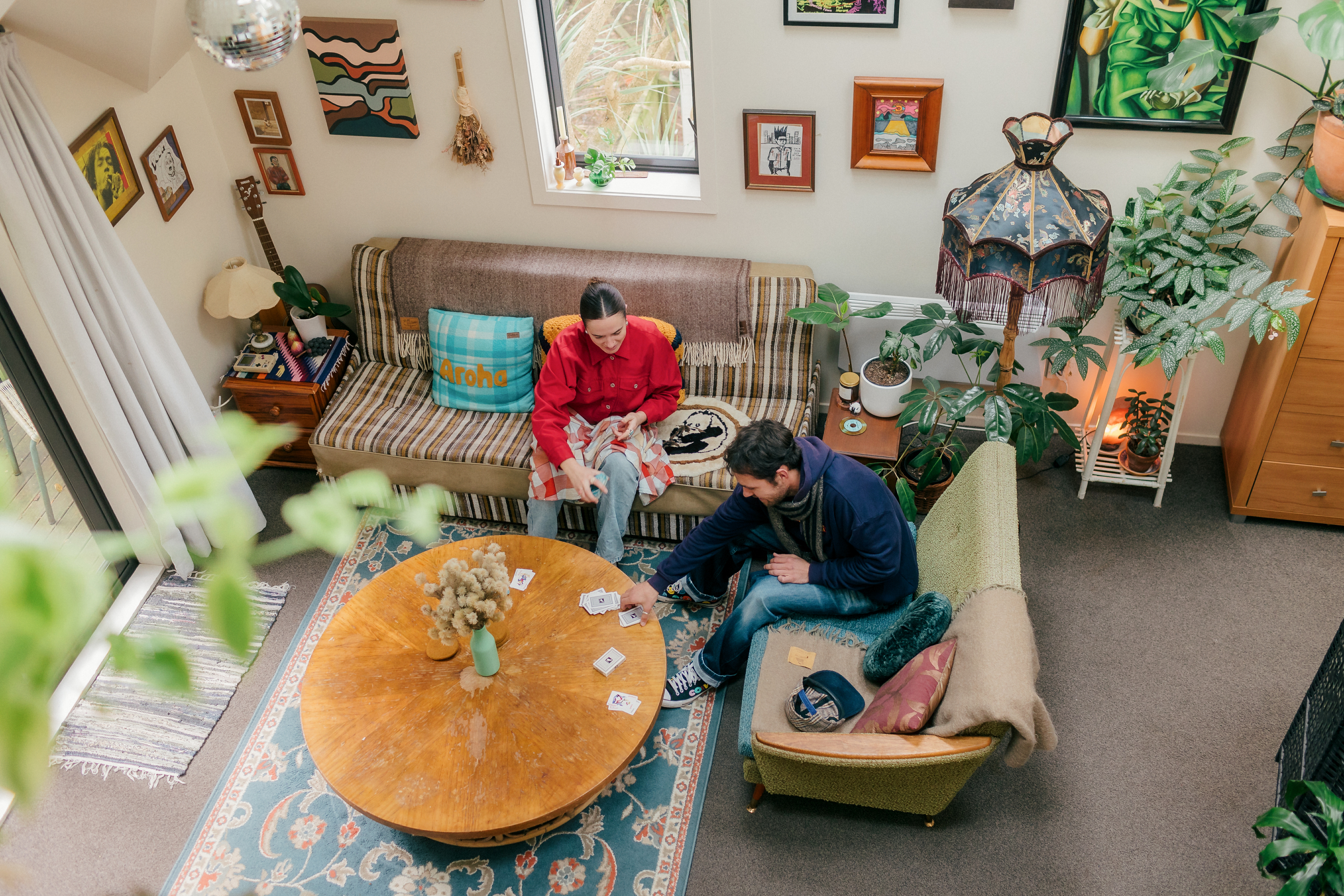 Birds eye view of Hana and Finnley playing cards on their coffee table