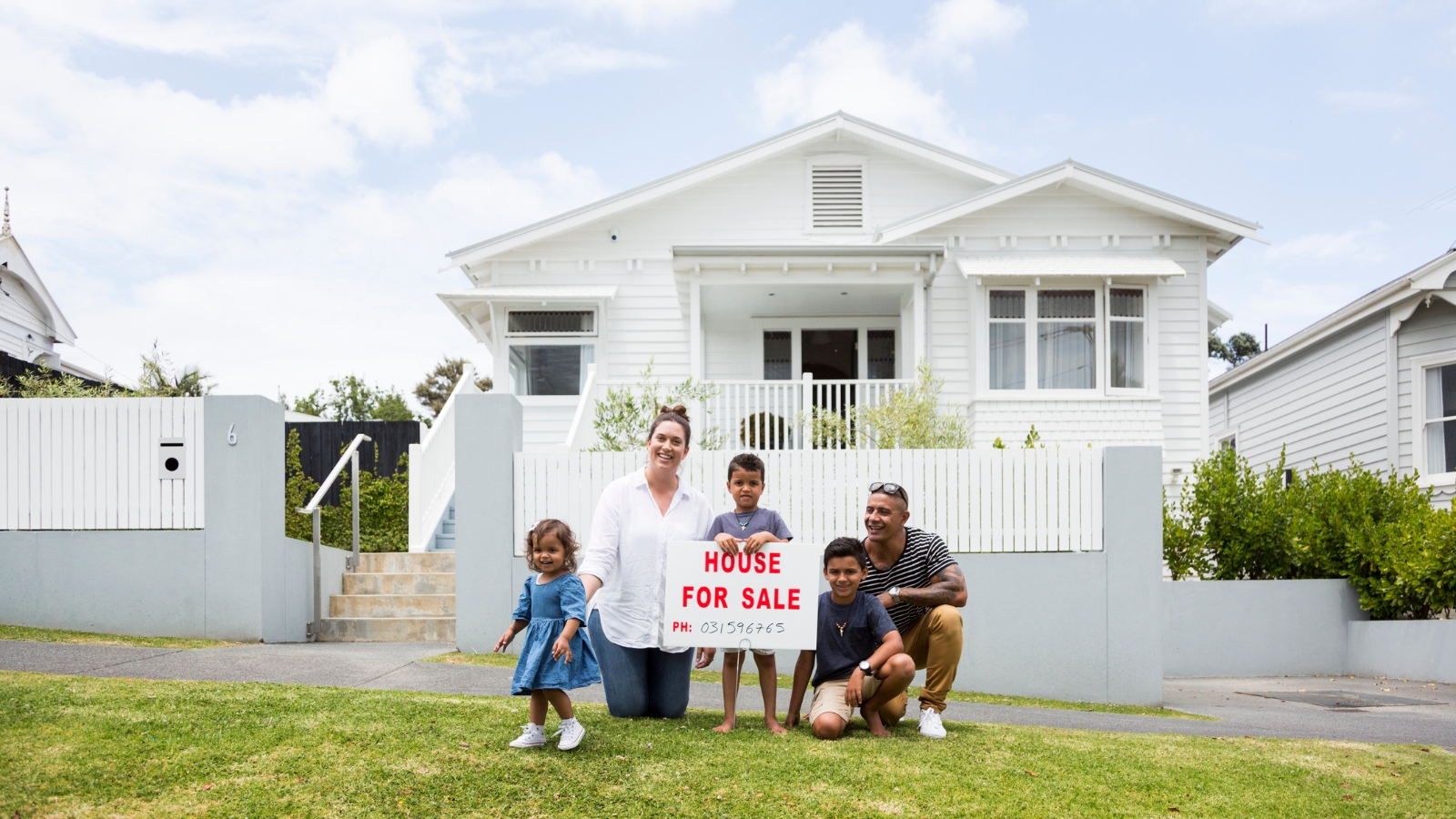 Family in front of home for sale. 