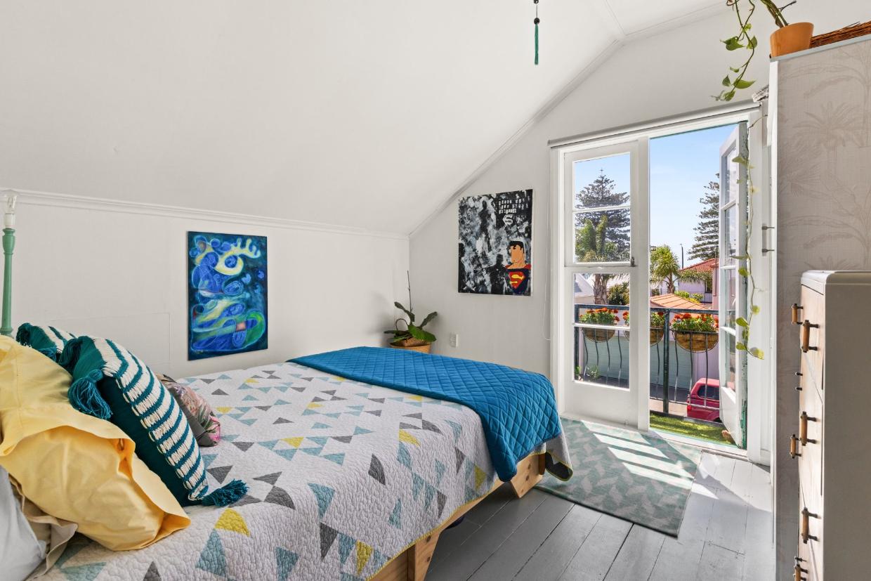 The upstairs bedroom opens to a balcony at the front of the house