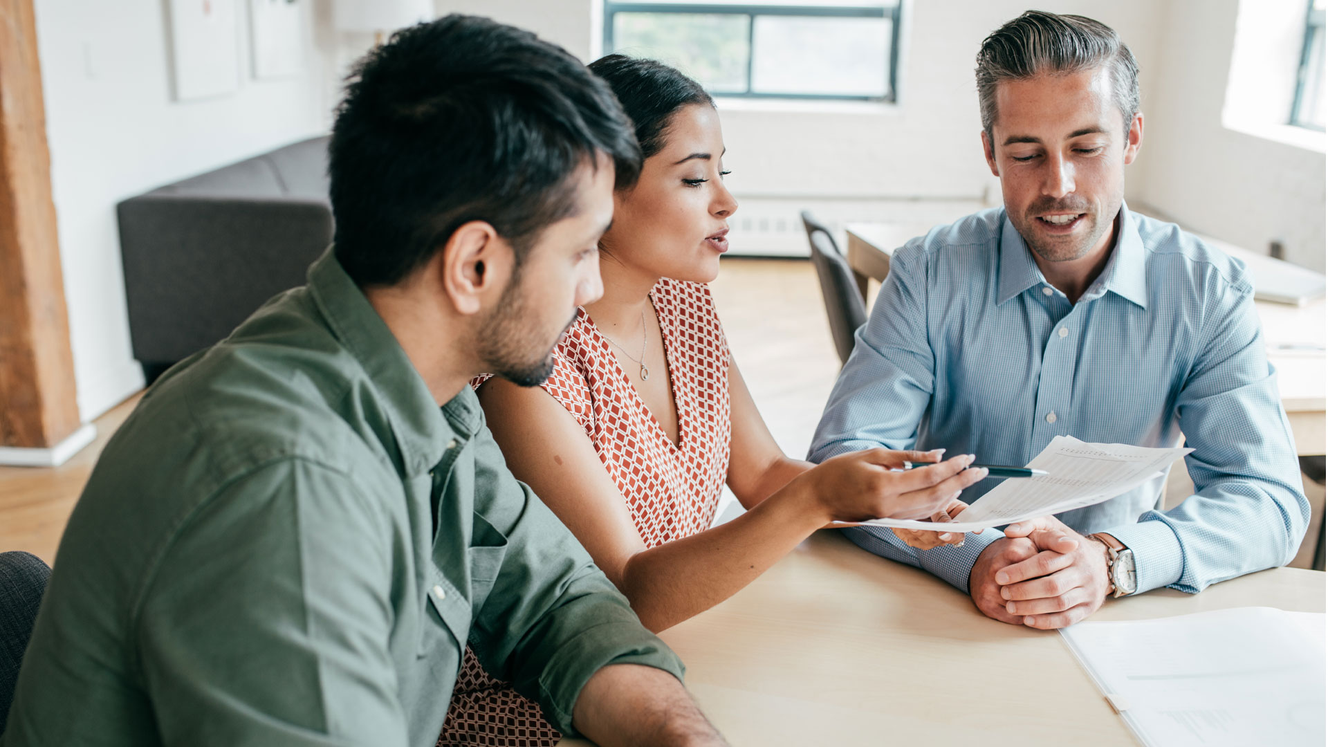 A couple working through some important paperwork with their real estate agent.