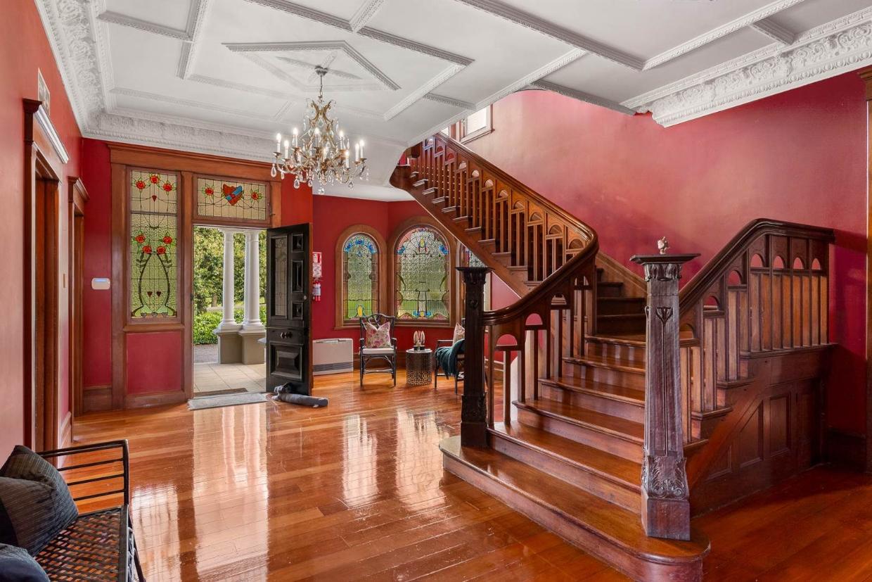 Grand mansion entrance with wooden stair case 