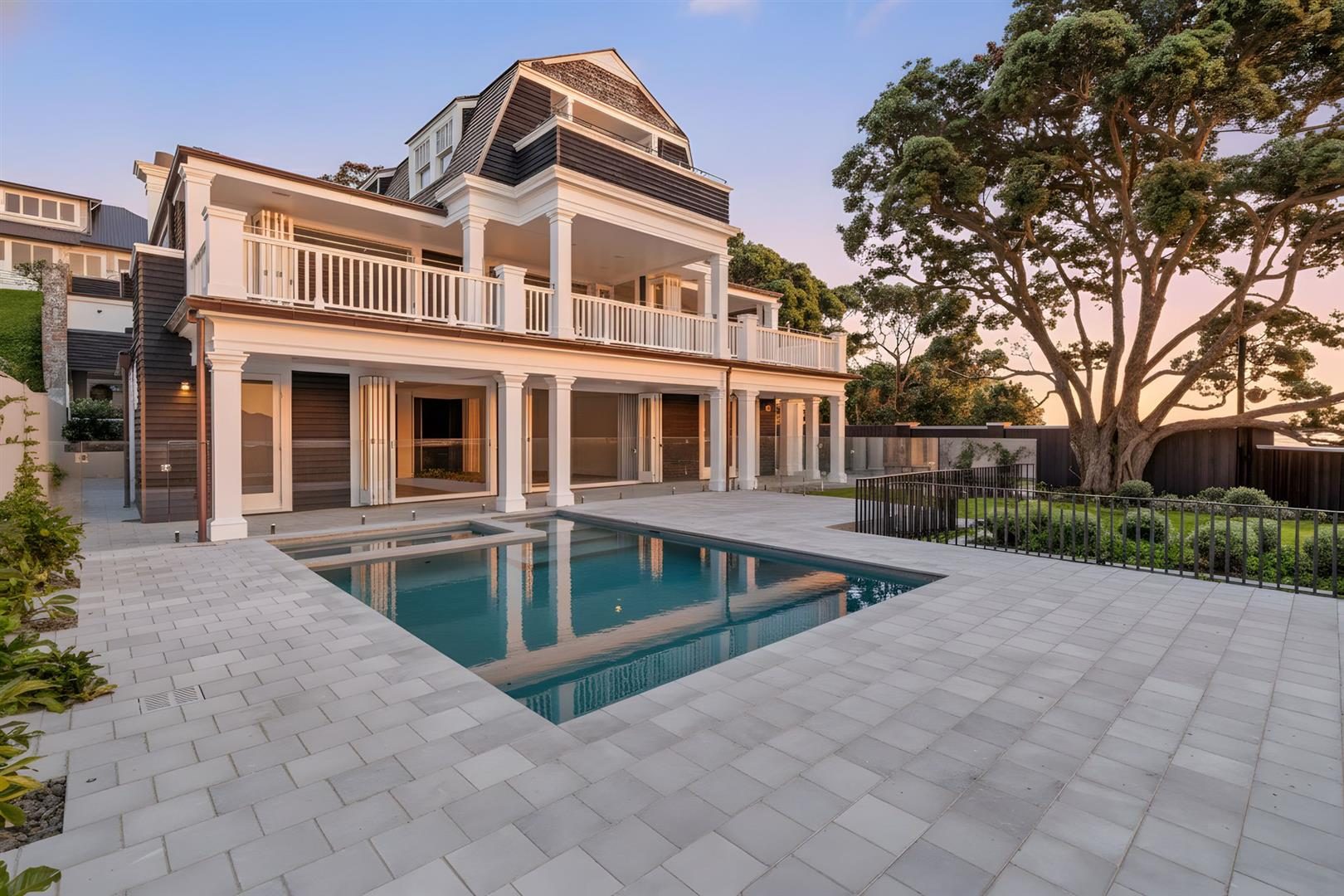 Three-storey colonial-style home with columned verandahs, pool and paved terrace at 29 Minnehaha Avenue, Takapuna, Auckland