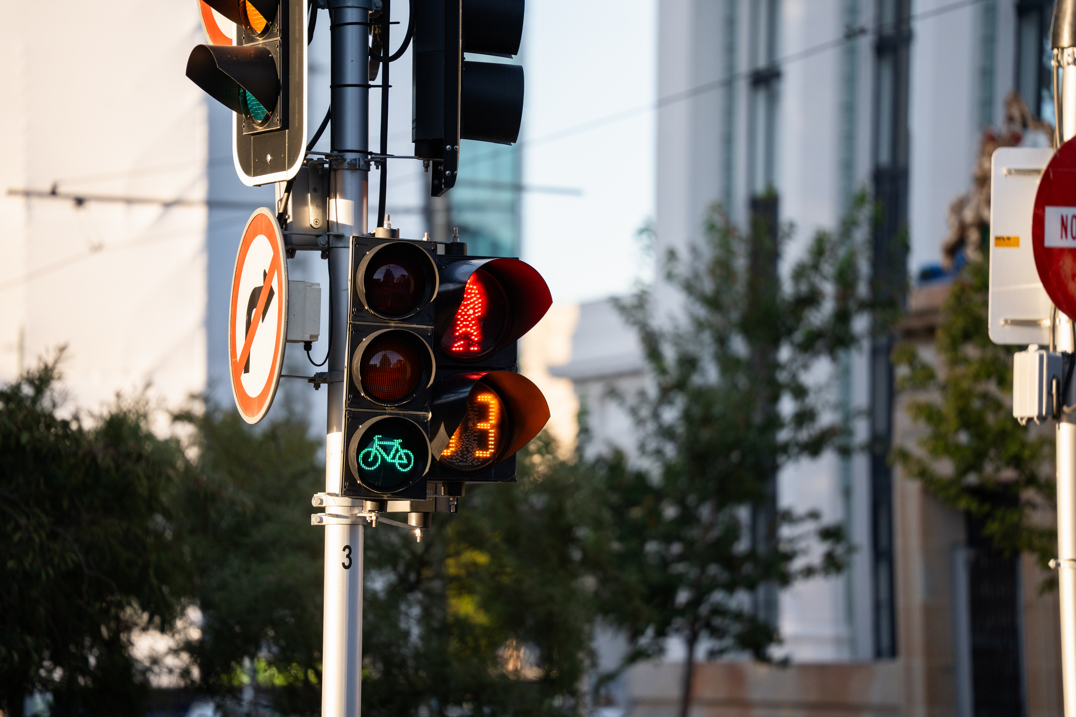Sidewalk crossing light and green and red traffic light
