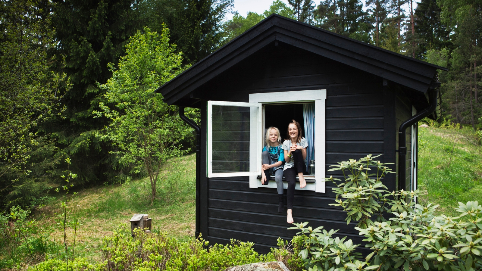 Granny flat with two kids sitting at window. 