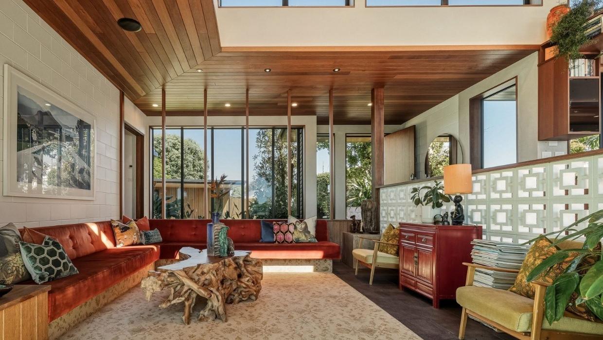 The conversation pit in the living room includes an orange wrap around couch.