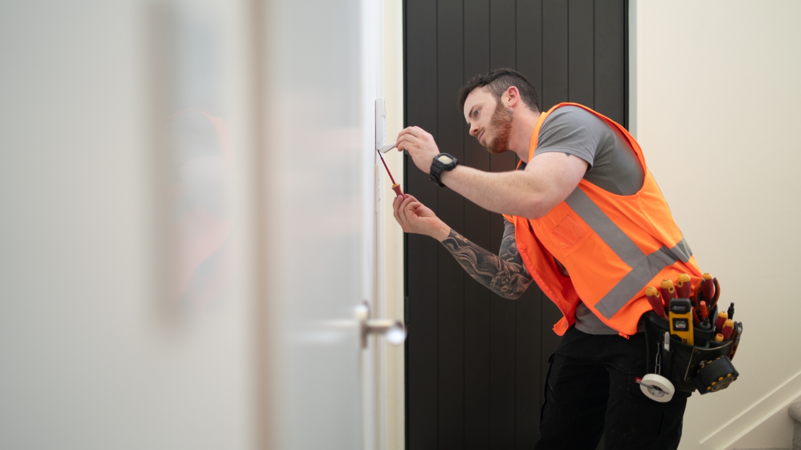  Man inspecting house in high vis vest