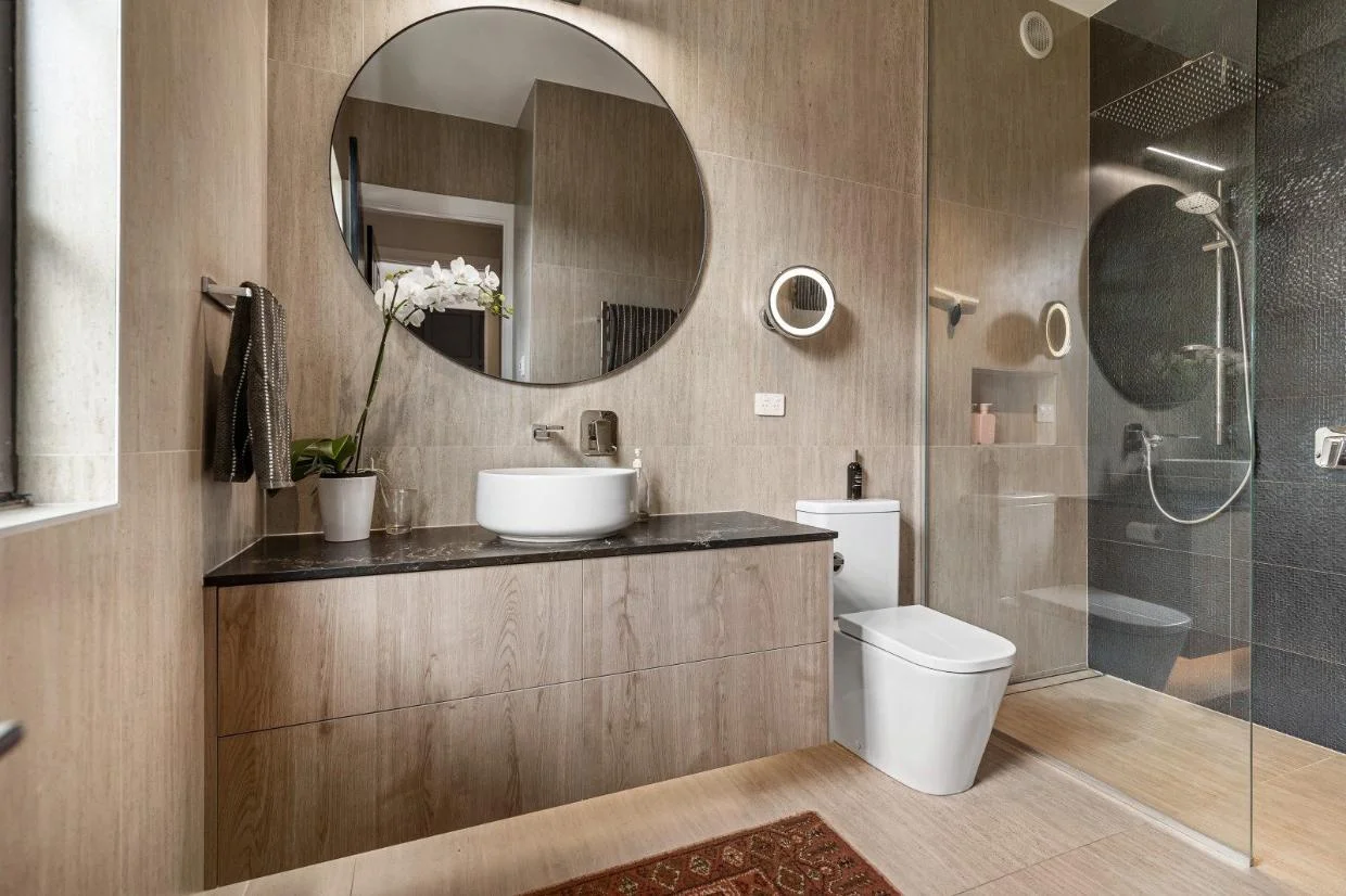 Bathrooms are beautifully tiled with timber veneer vanities.