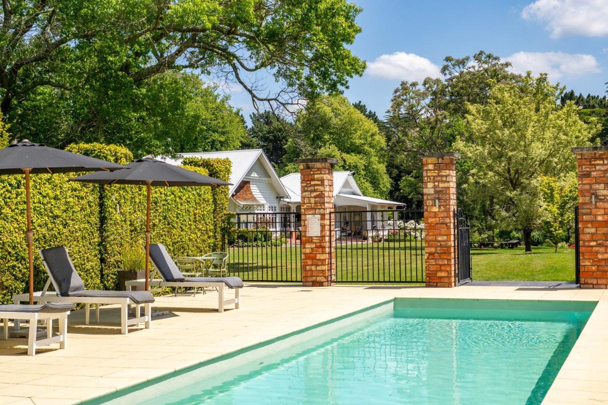 The estate includes a pool and pool house as well as tennis courts.