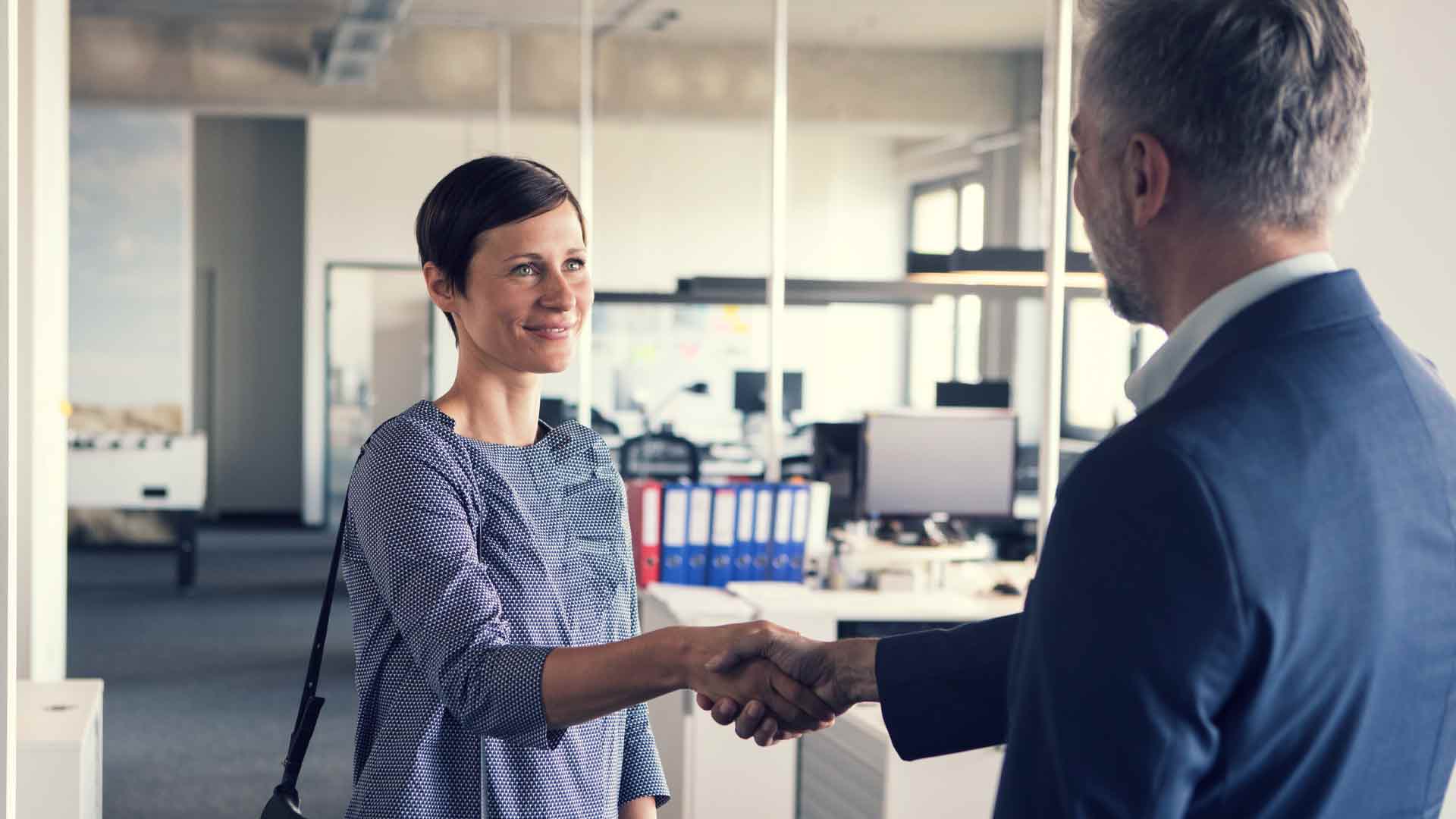Resigning employee shaking hands with her manager.