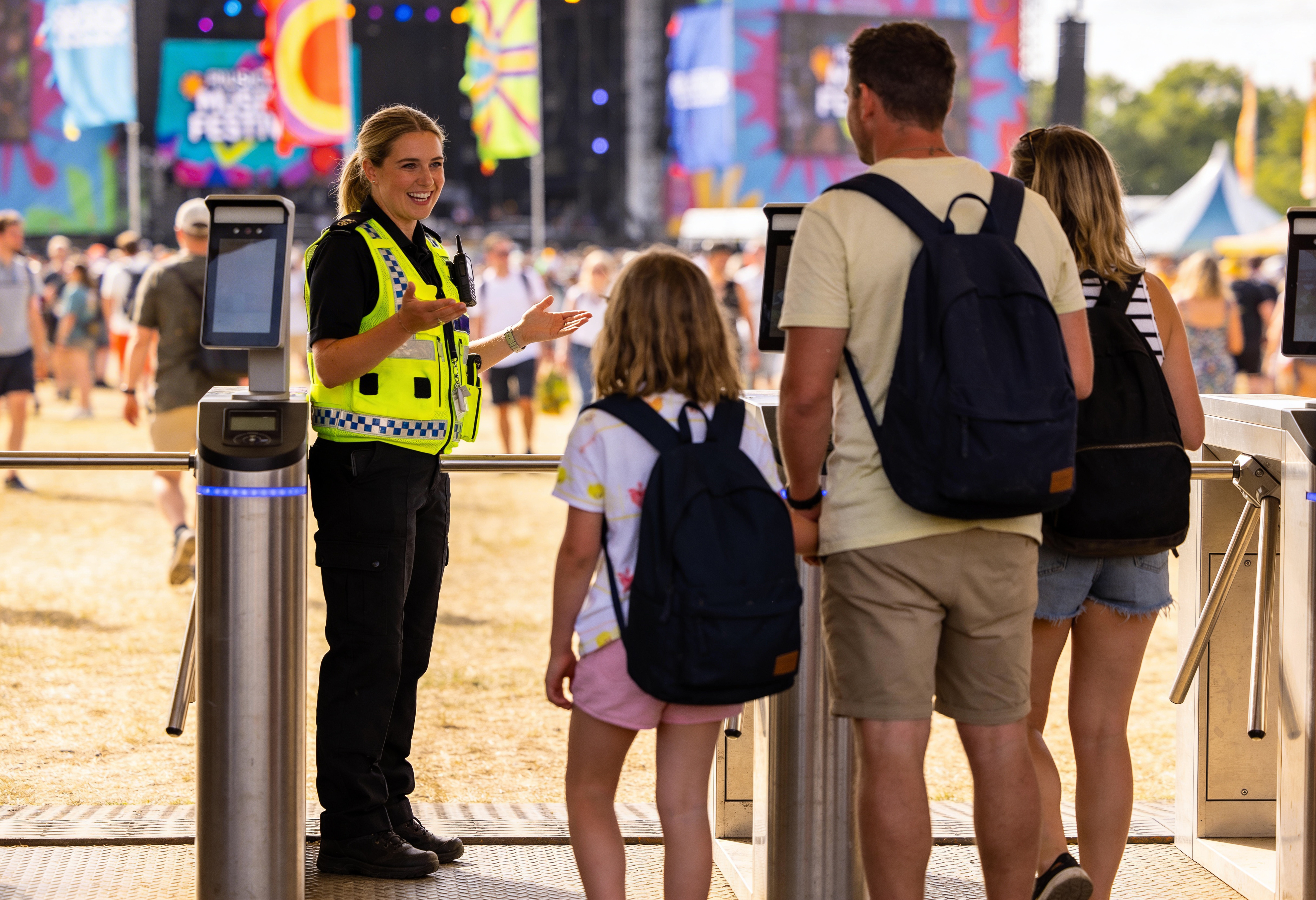 Female security guard at a music festival talking with a family