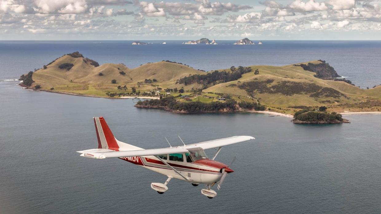 Slipper Island/Whakahau is off the Coromandel coast. Image of small plane flying over the island.