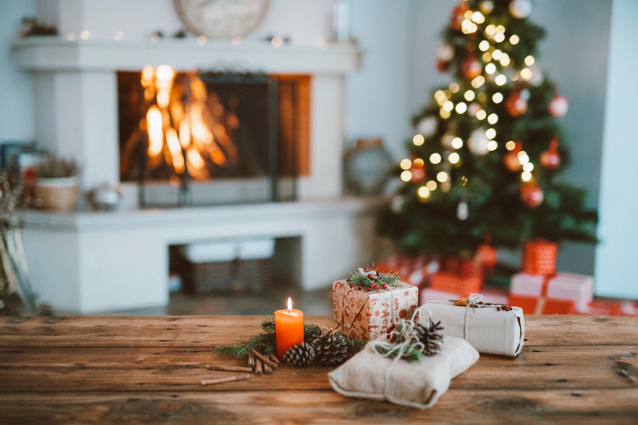 Rustic wrapped christmas gifts with tree and fireplace backdrop