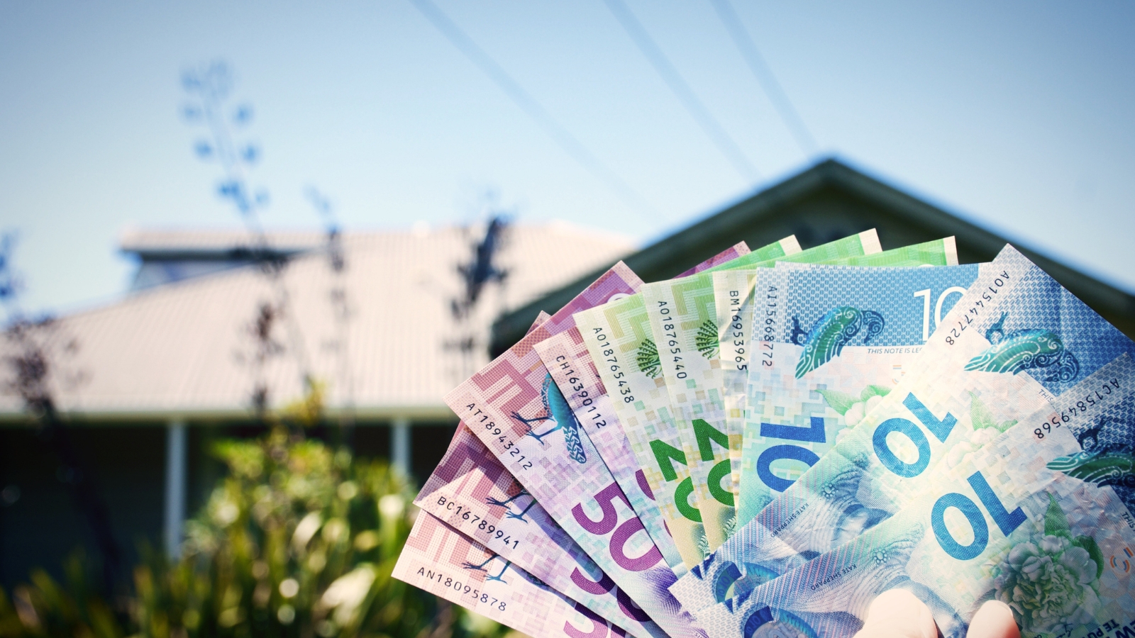 Cash held up in front of house. 