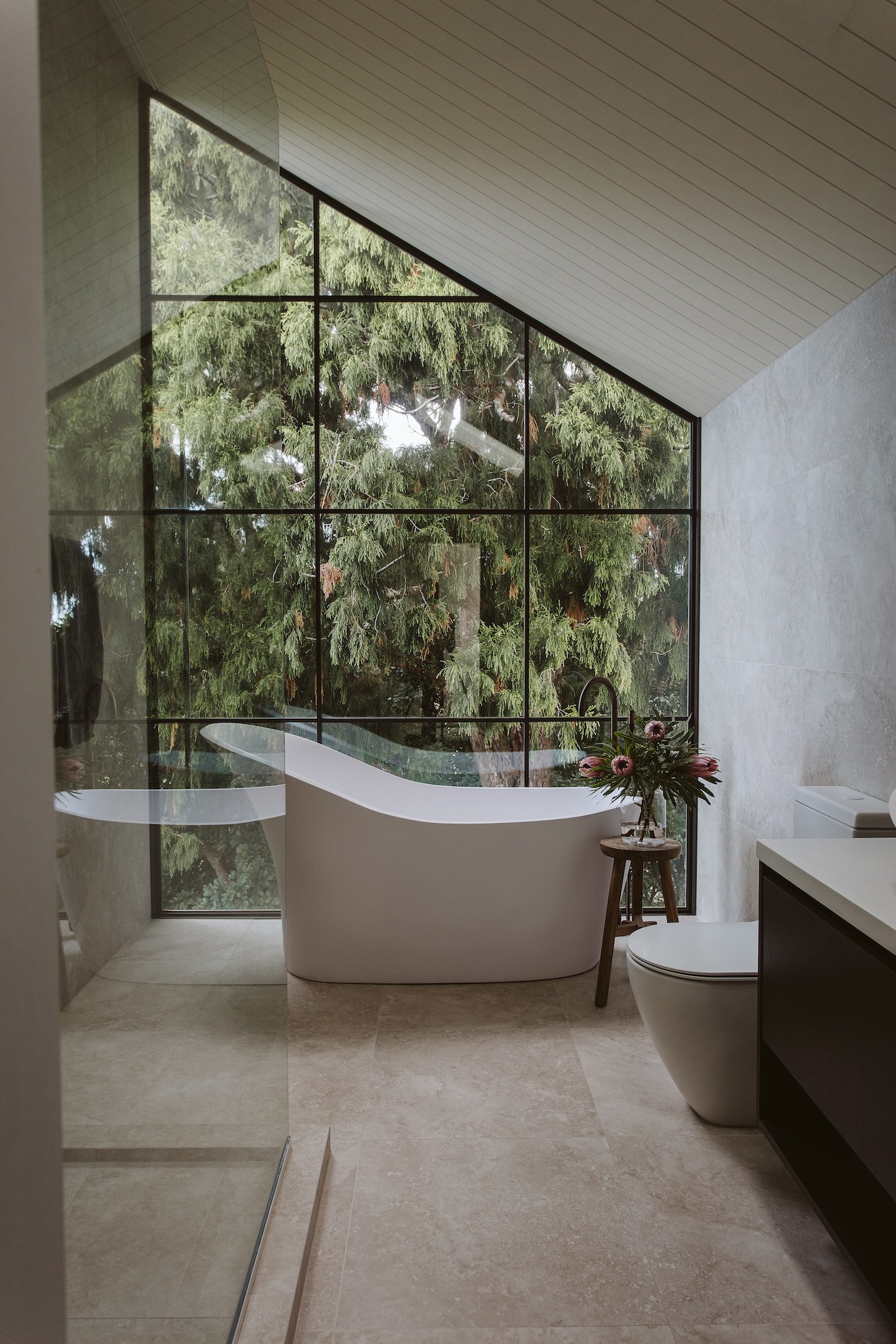 Whether the rain is dropletting down the big window or the setting sun is sprinkling through the bush, Jemma loves to relax in the Ava bath, which teams with a slipper-shaped Ava basin in the ensuite. The walls and floor are tiled in Roma Cream and the gooseneck tap is a Buddy X Floormount Bath Filler from Plumbline in aged brass.