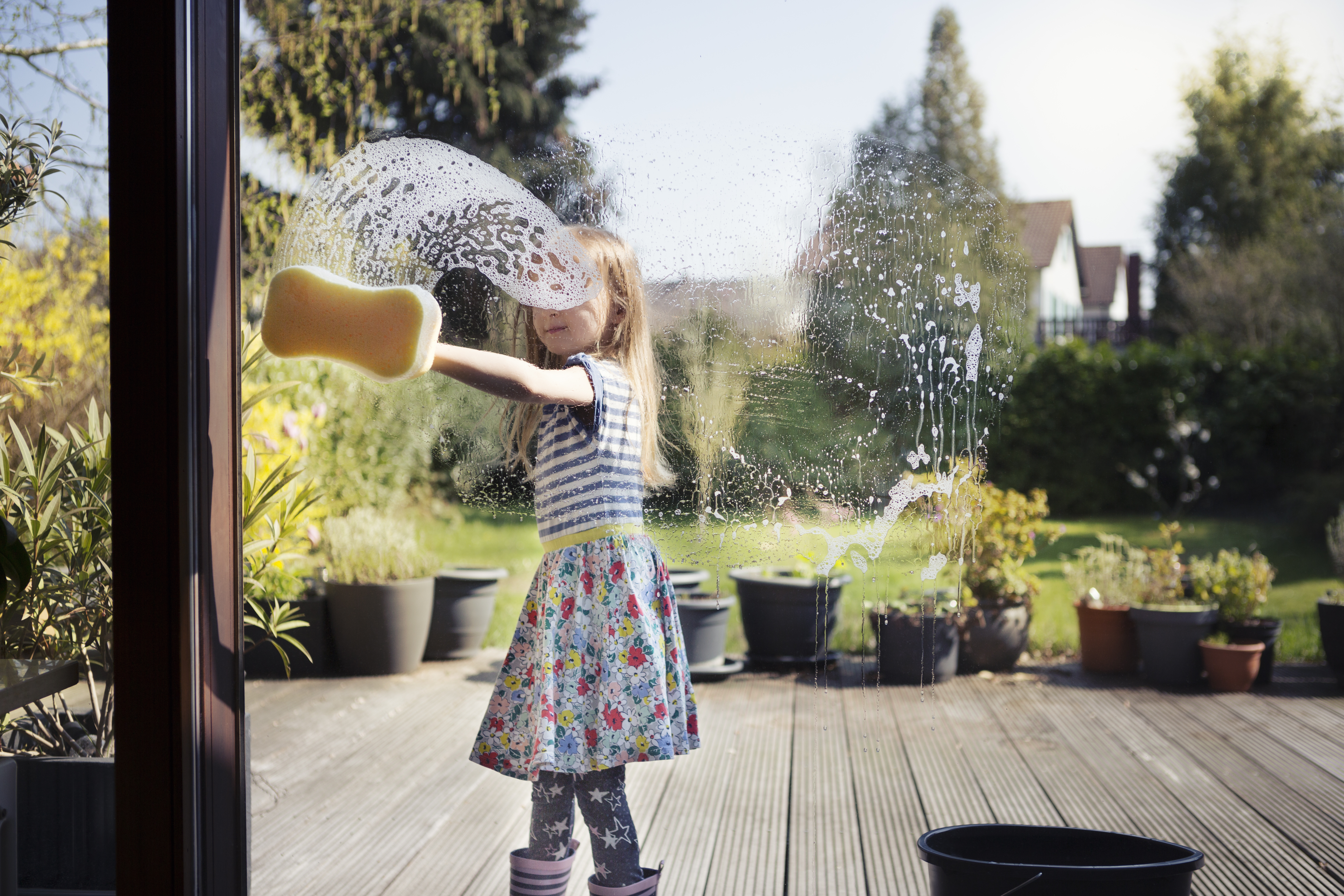 A girl cleaning her patio windows