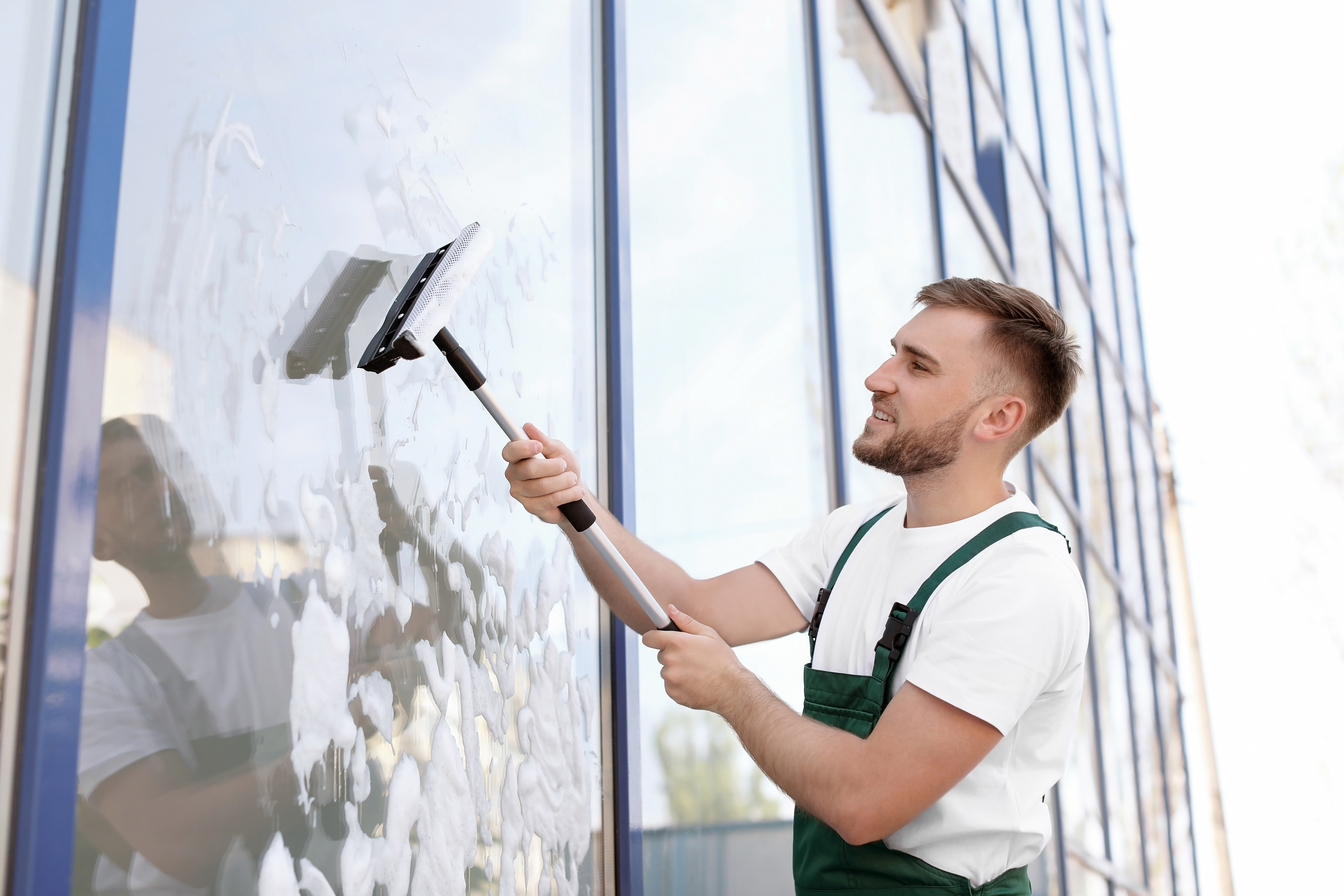 Male cleaner cleaning a window.