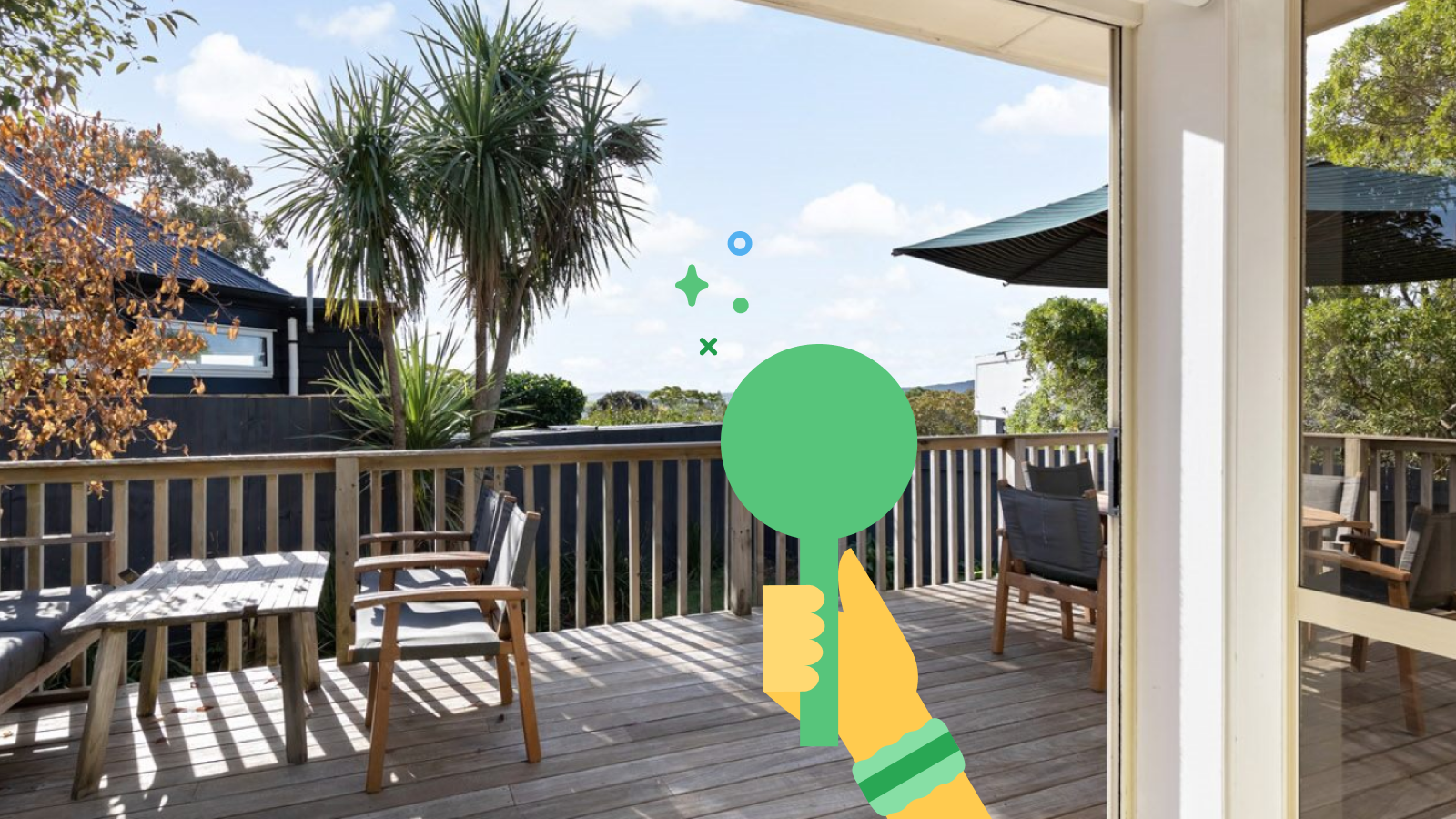 Looking out onto a deck with a view of trees and the ocean, an illustration of a yellow hand holding a green bidding paddles with sparkles over it.