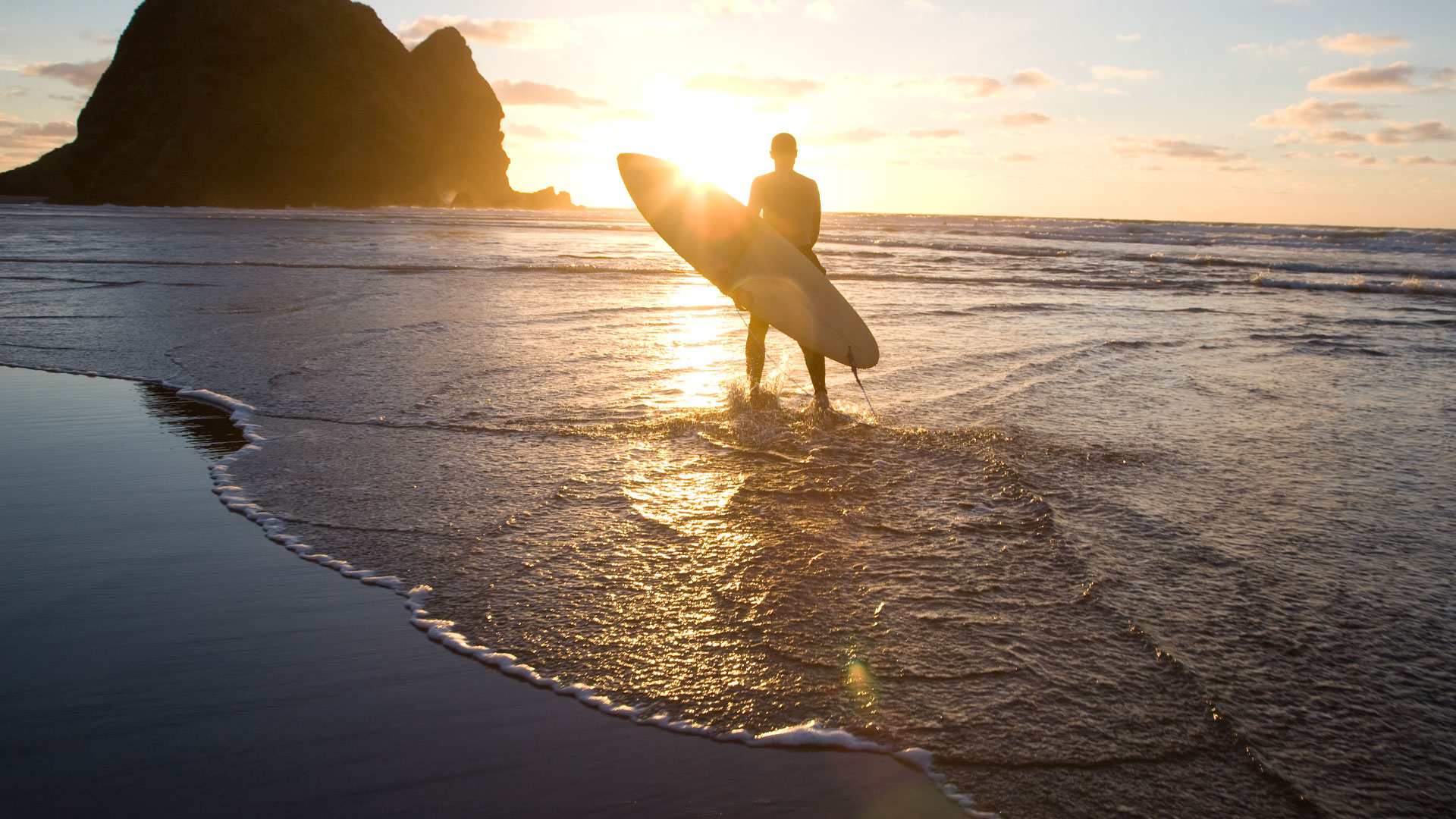 Man surfing at Piha Beach near Auckland.