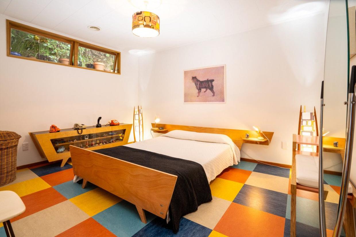 Chris Williams designed much of the furniture in the house, and had it made, including the glass cabinet in the main bedroom. He made the bed himself. Photo: Lowe & Co
