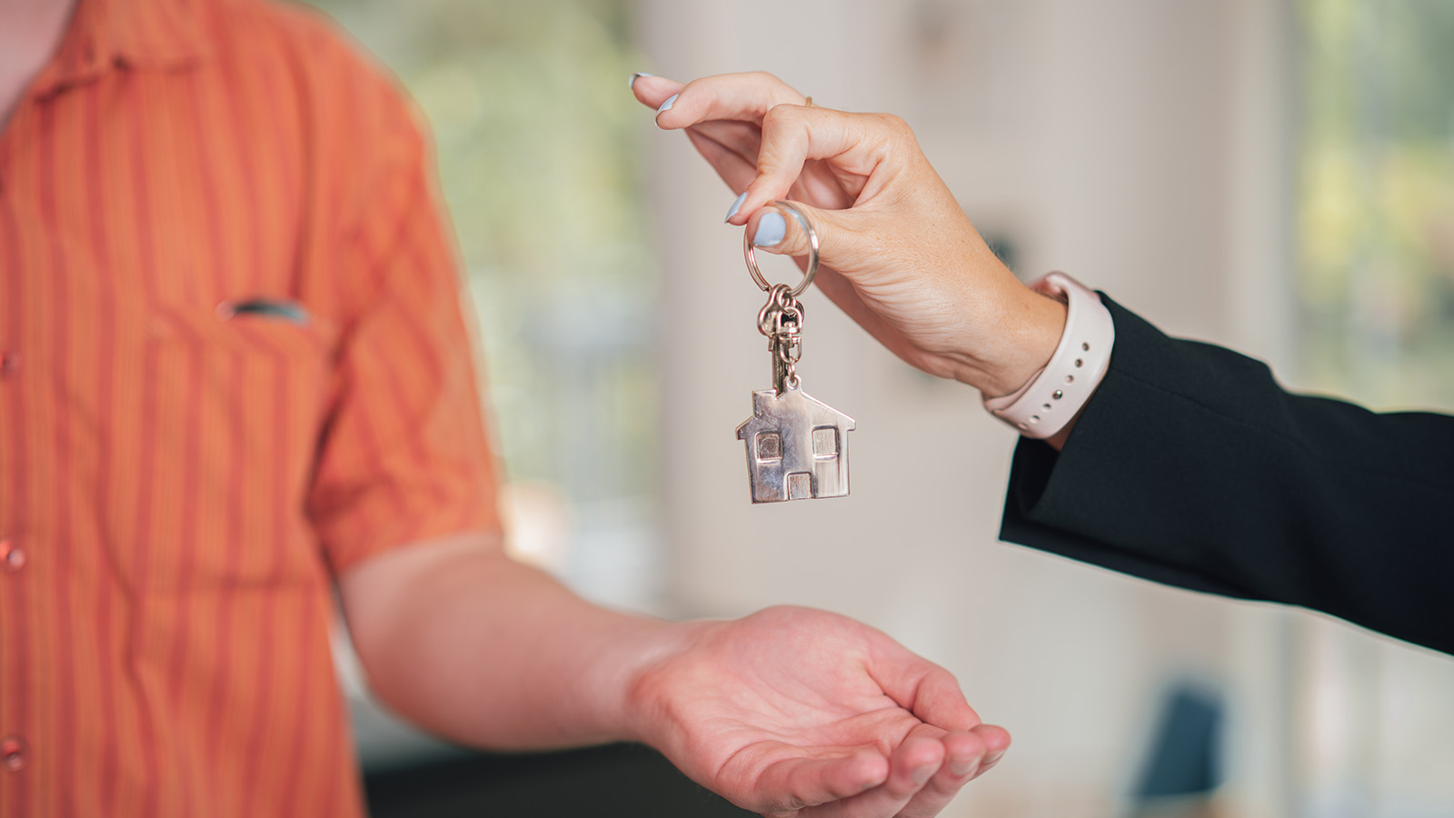 Person hands over the keys to a house