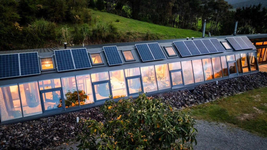 The Earthship has four bedrooms, but is just one room deep, with a long conservatory-style corridor on the north side, featuring plants. The couple sell surplus energy from their solar panels to the national grid. Photo: Pete May