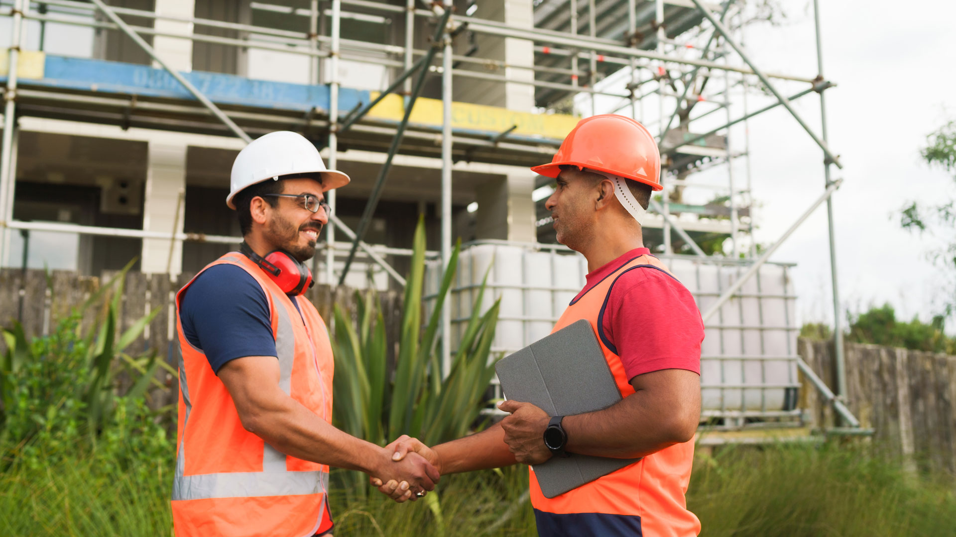 Two trades people shaking hands on a worksite