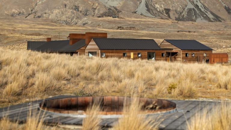 As planned, the house nestles unobtrusively into the rugged landscape. Photo: NZ Sotheby's