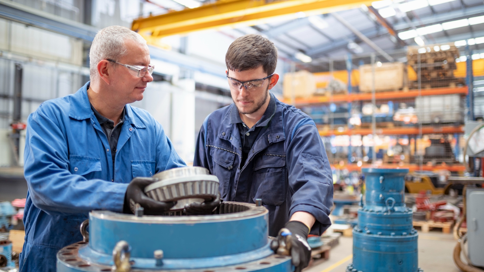 Man teaching apprentice in workshop. 
