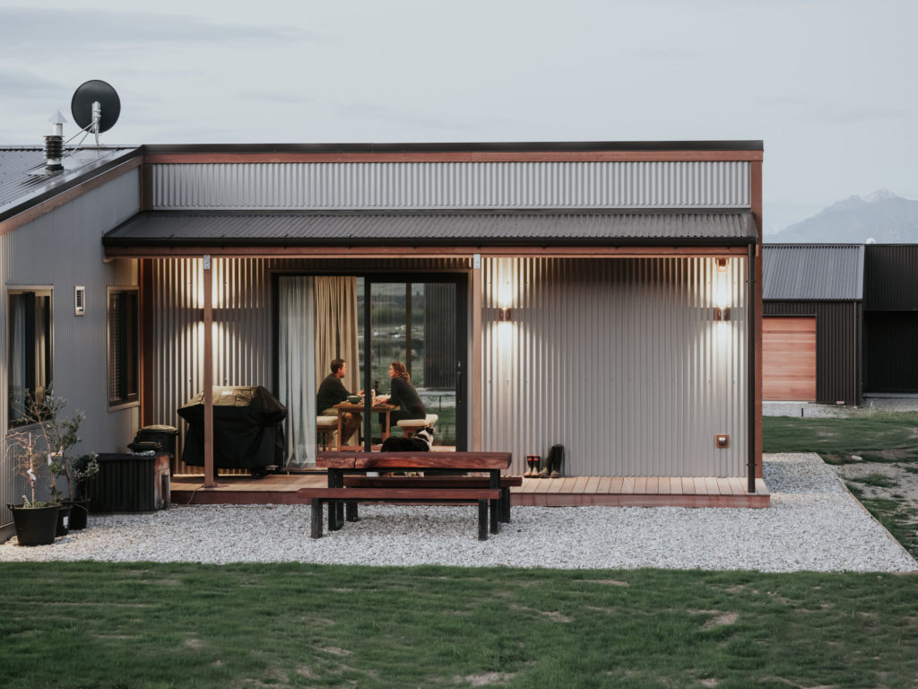 Outside view of corrugated iron home with snowcapped mountains in distance