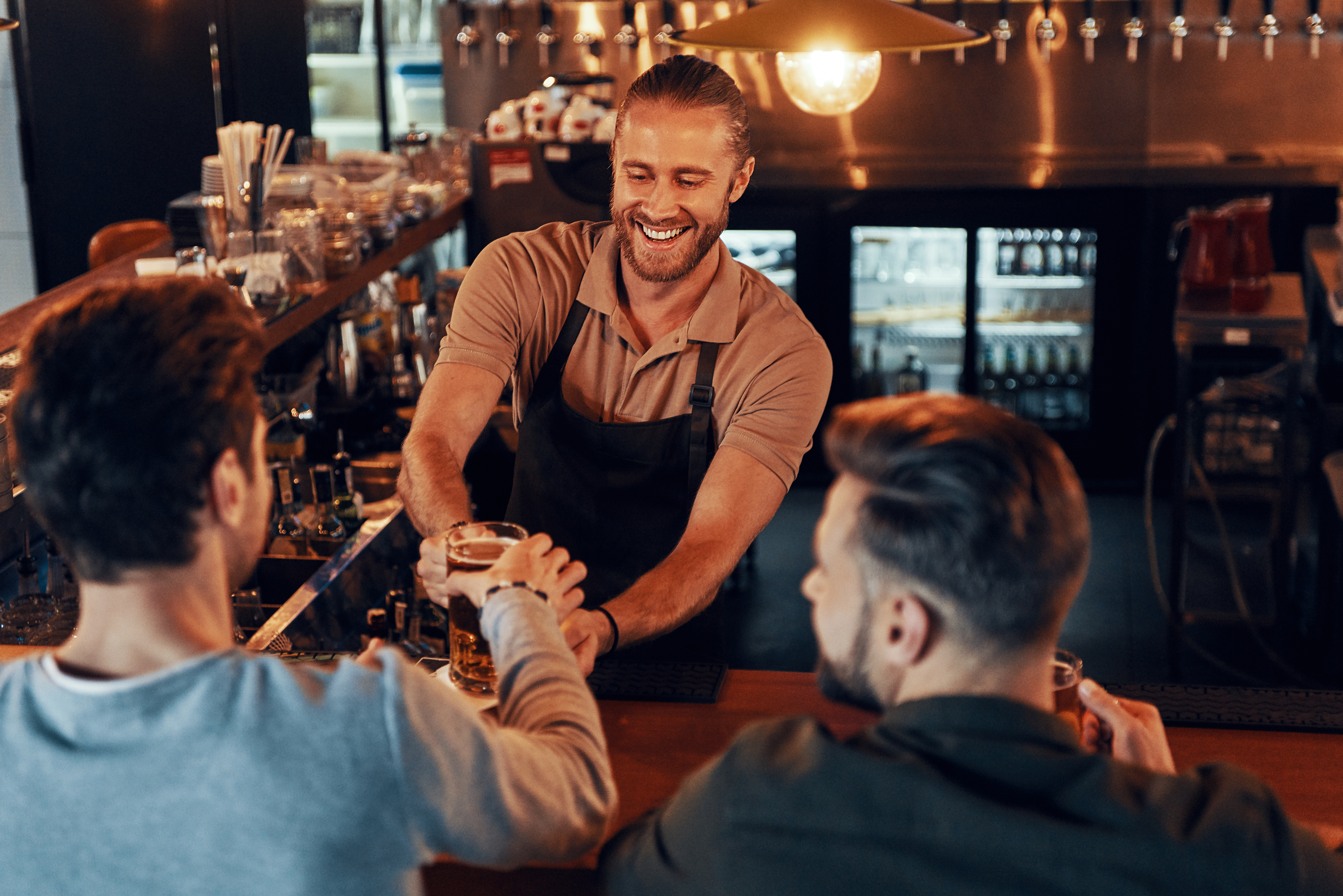 Male bartender serving customers