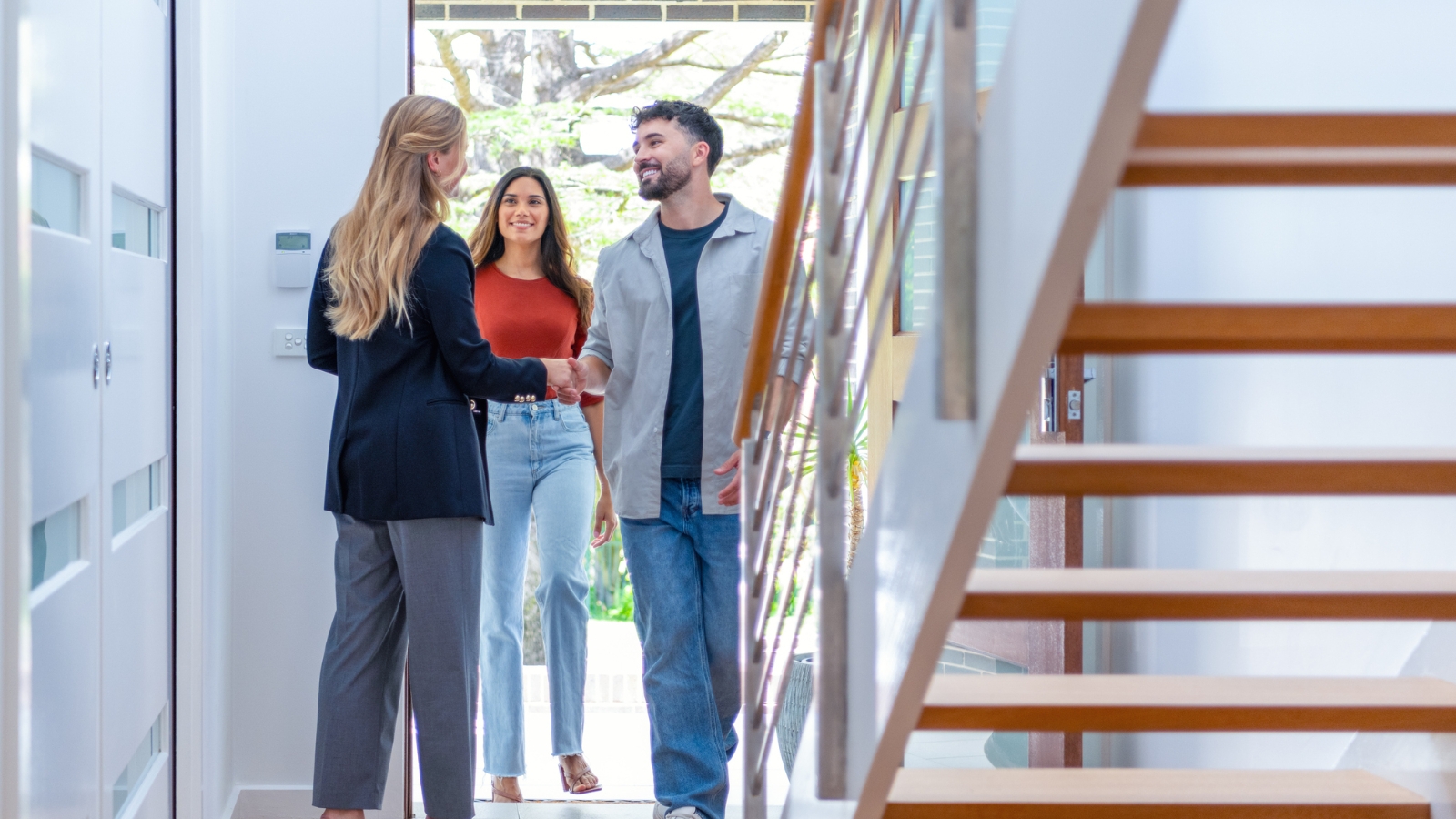 Real estate agent showing couple through house. 